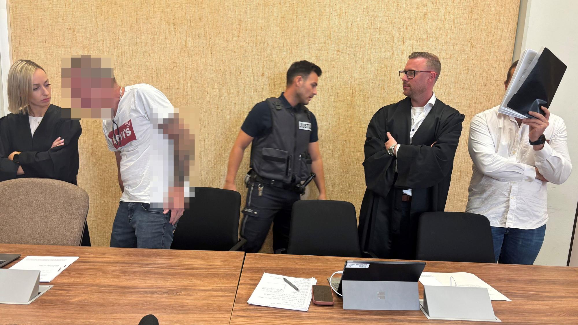 Angeklagte und Verteidiger stehen vor dem Kölner Landgericht.