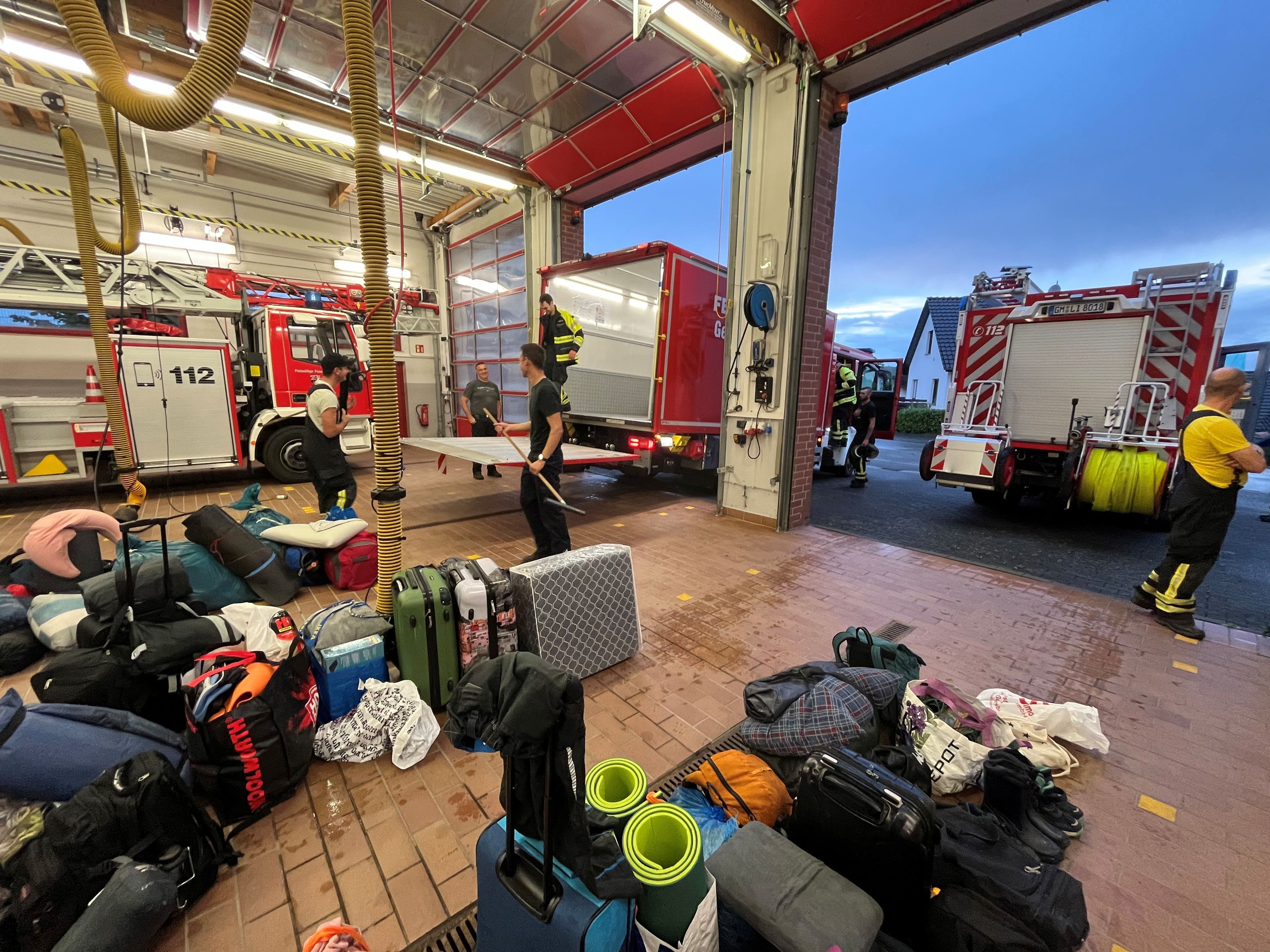 In einer Halle eines Feuerwehrgerätehauses steht Reisegepäck.