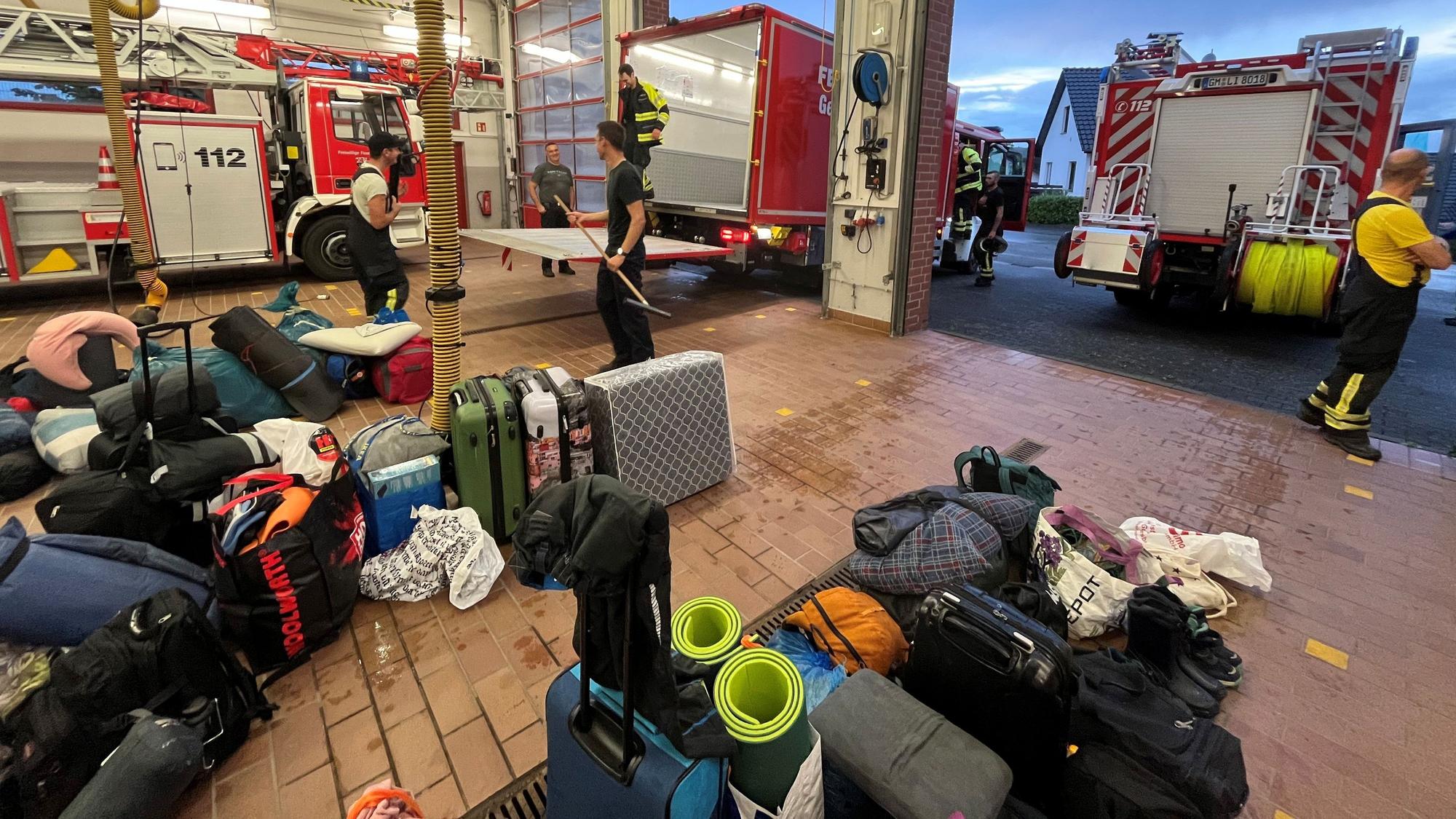 In einer Halle eines Feuerwehrgerätehauses steht Reisegepäck.