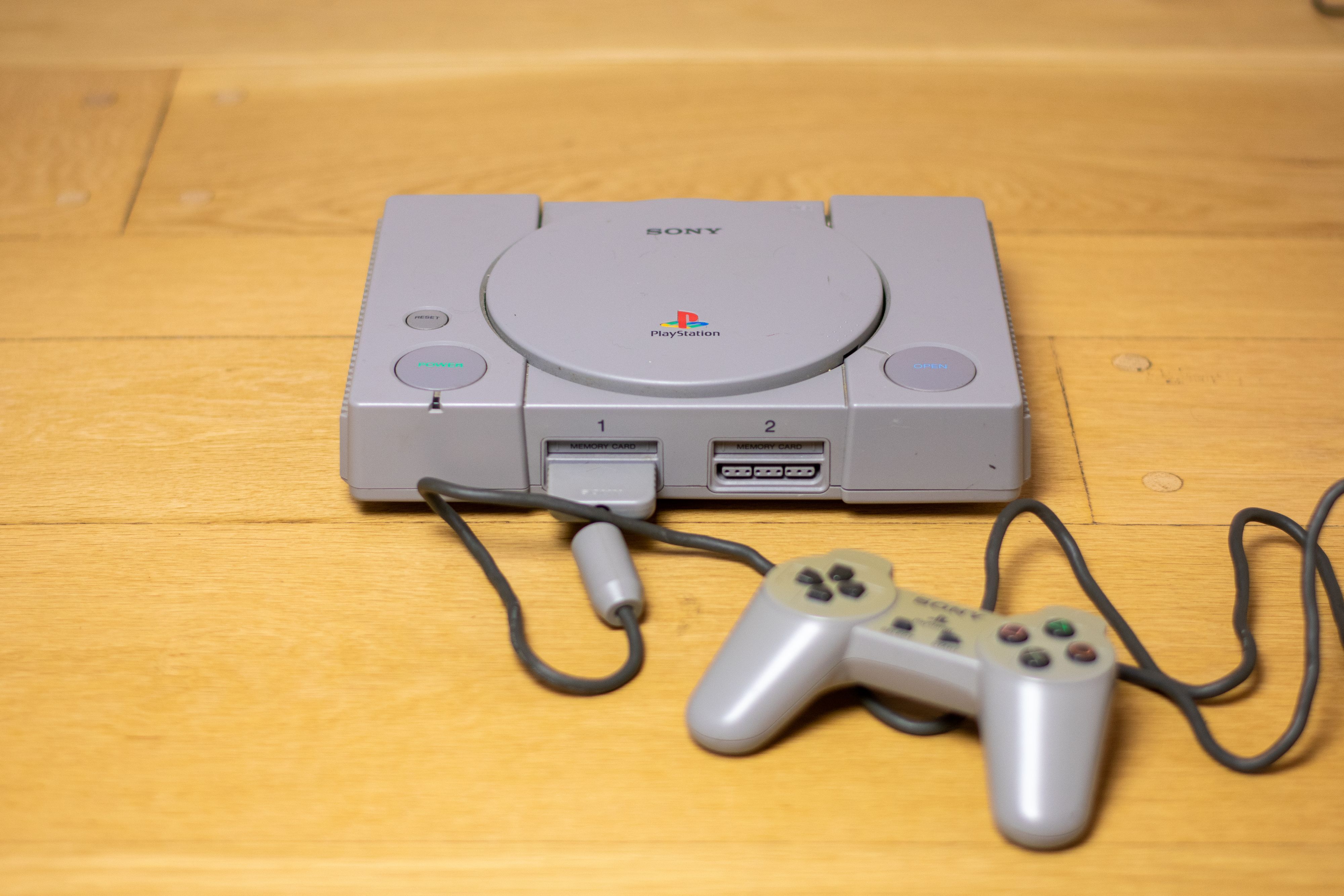 Die graue Kiste, die alles veränderte: Die originale Sony PlayStation 1 mit Controller und Memory Card.