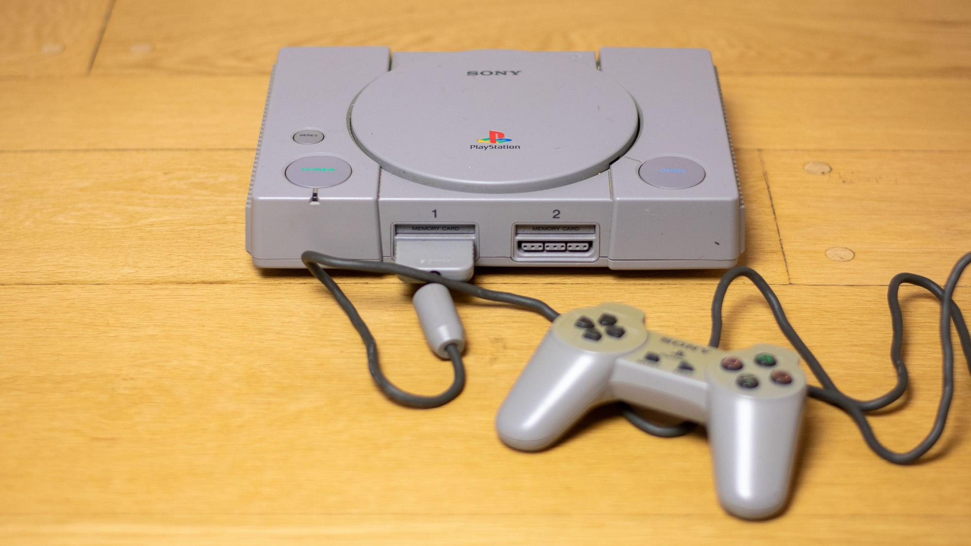 Die graue Kiste, die alles veränderte: Die originale Sony PlayStation 1 mit Controller und Memory Card.