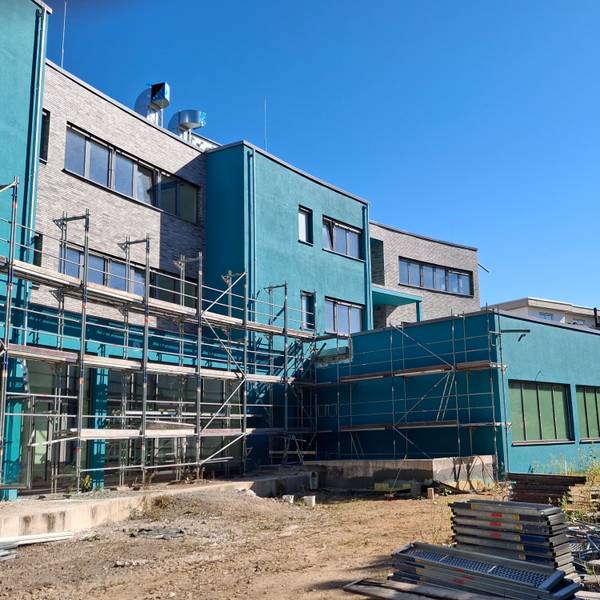 Die Baustelle besteht aus türkisen unfertigen Gebäuden, die eingezäunt sind.