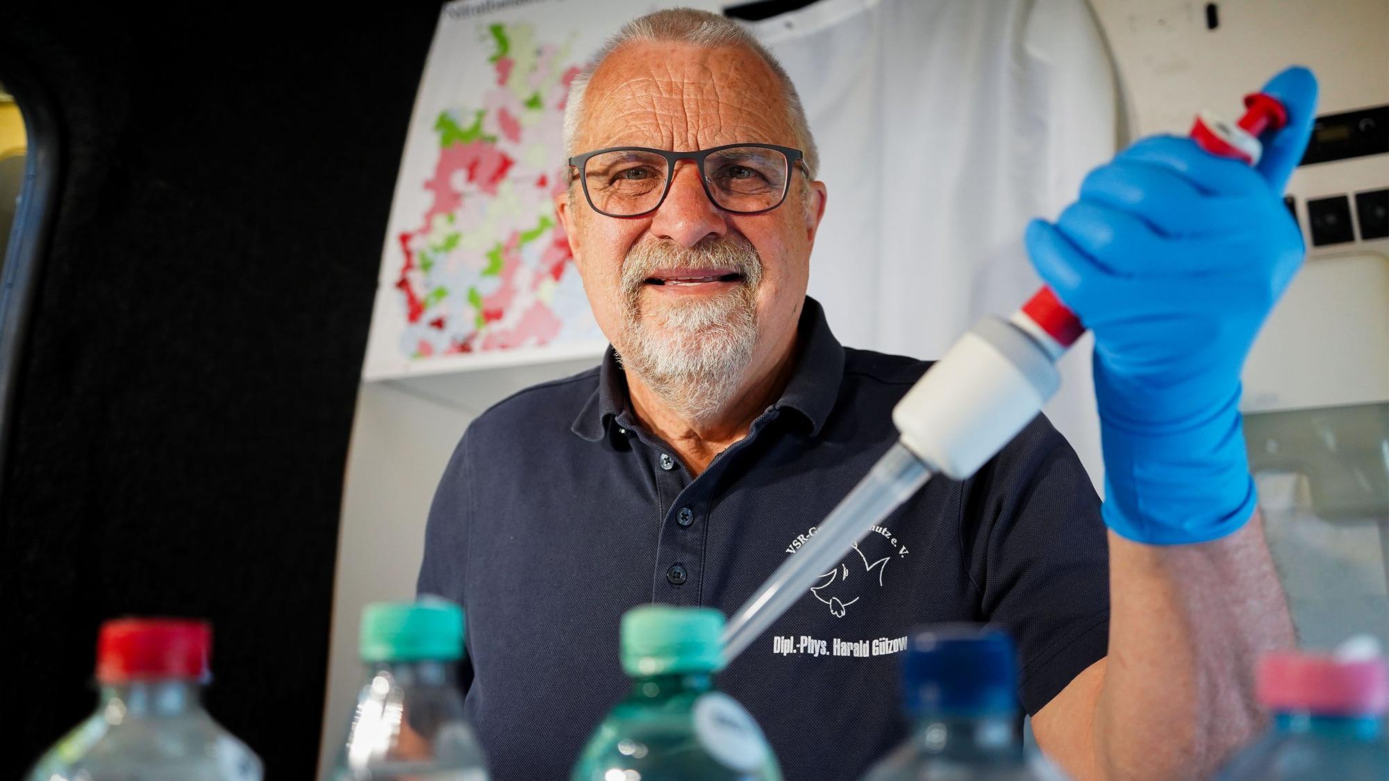 Harald Gülzow analysiert eine Brunnenwasserprobe im Labormobil des VSR-Gewässerschutzes mit einer großen Pinzette.