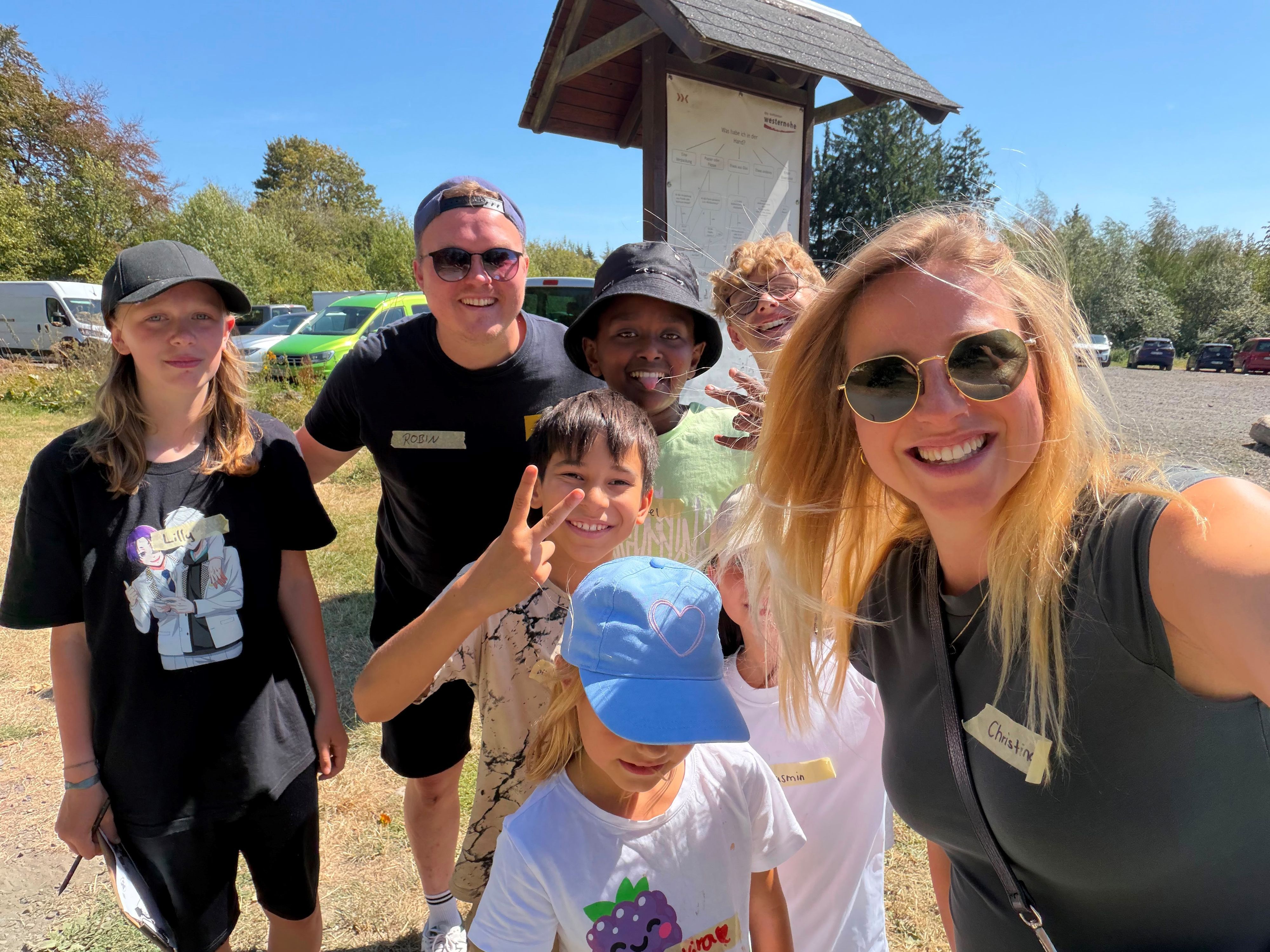 Christina Linzenich macht ein Selfie von sich und einer Gruppe von Kindern und Betreuer Robin.