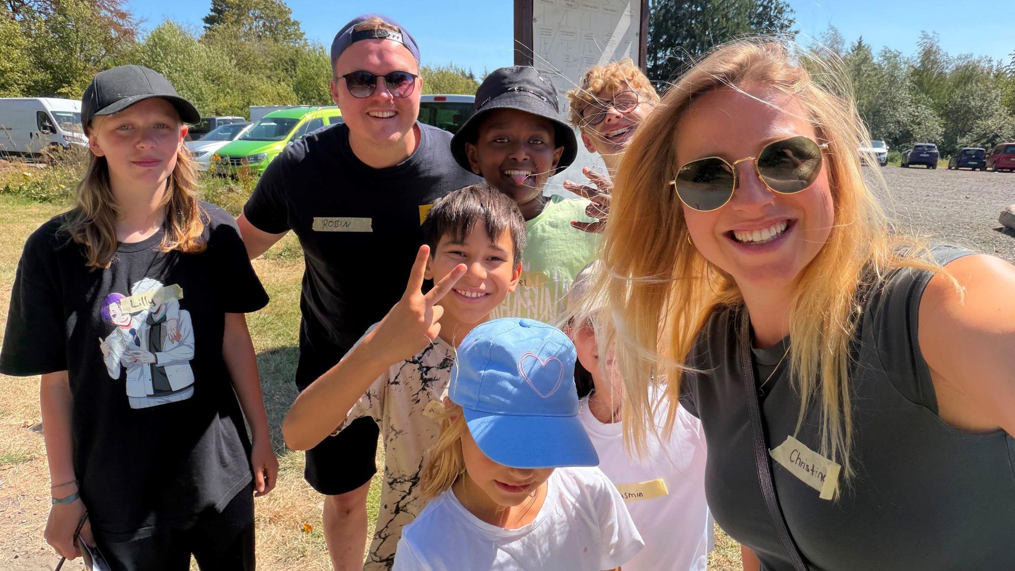 Christina Linzenich macht ein Selfie von sich und einer Gruppe von Kindern und Betreuer Robin.
