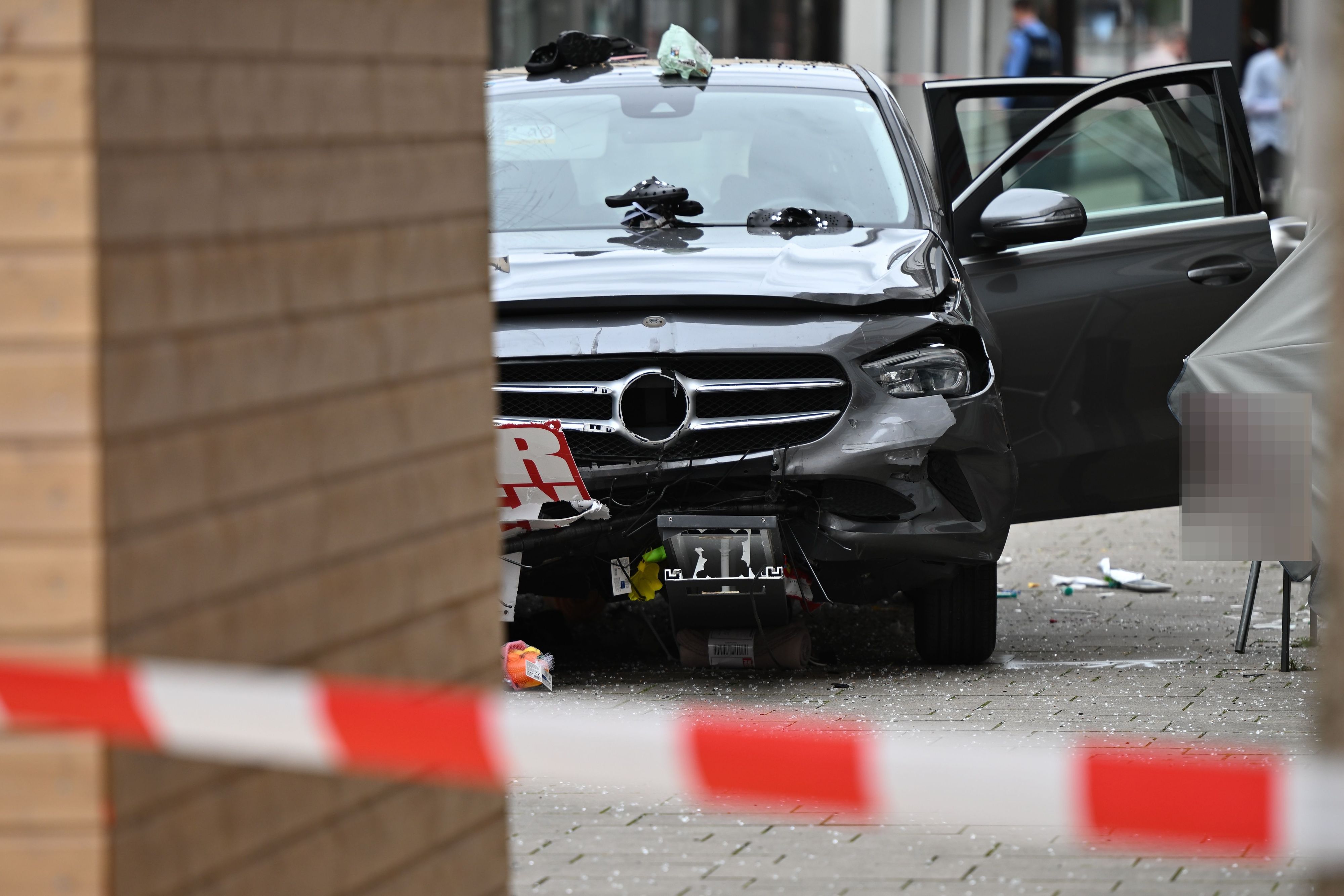 Ein beschädigtes Auto ist in der Nähe der Unfallstelle zu sehen. Ein Autofahrer raste am Vormittag mit hoher Geschwindigkeit durch die Fußgängerzone und verletzte dabei mehrere Menschen.