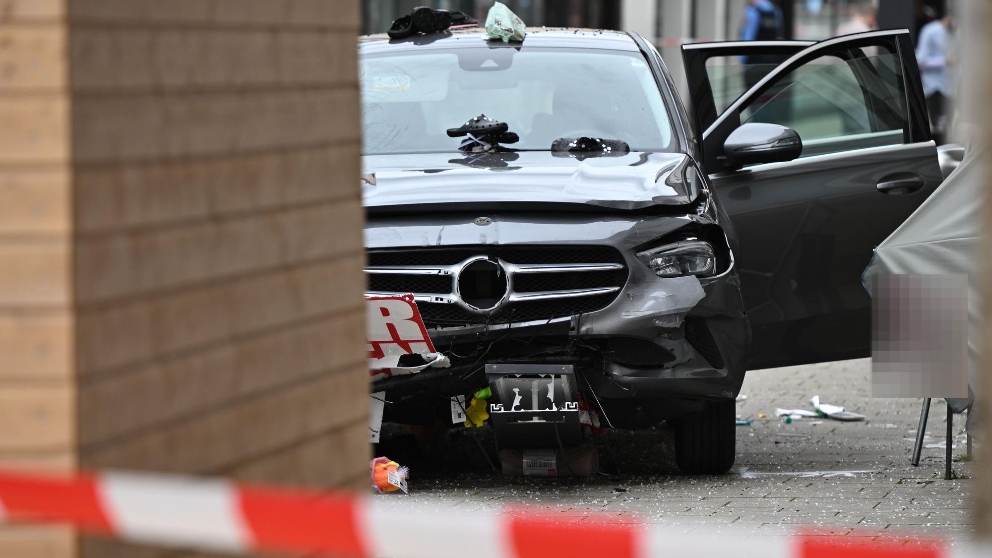 Ein beschädigtes Auto ist in der Nähe der Unfallstelle zu sehen. Ein Autofahrer raste am Vormittag mit hoher Geschwindigkeit durch die Fußgängerzone und verletzte dabei mehrere Menschen.