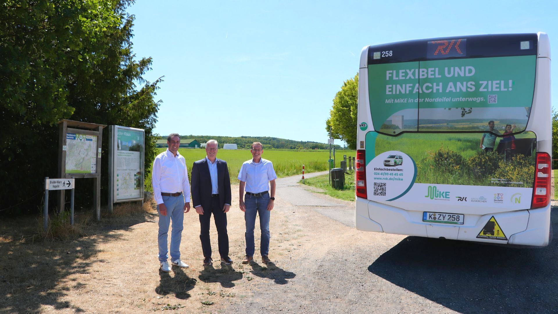 Die genannten Personen stehen neben einem RVK-Bus am Parkplatz der Bruder-Klaus-Kapelle bei Wachendorf.