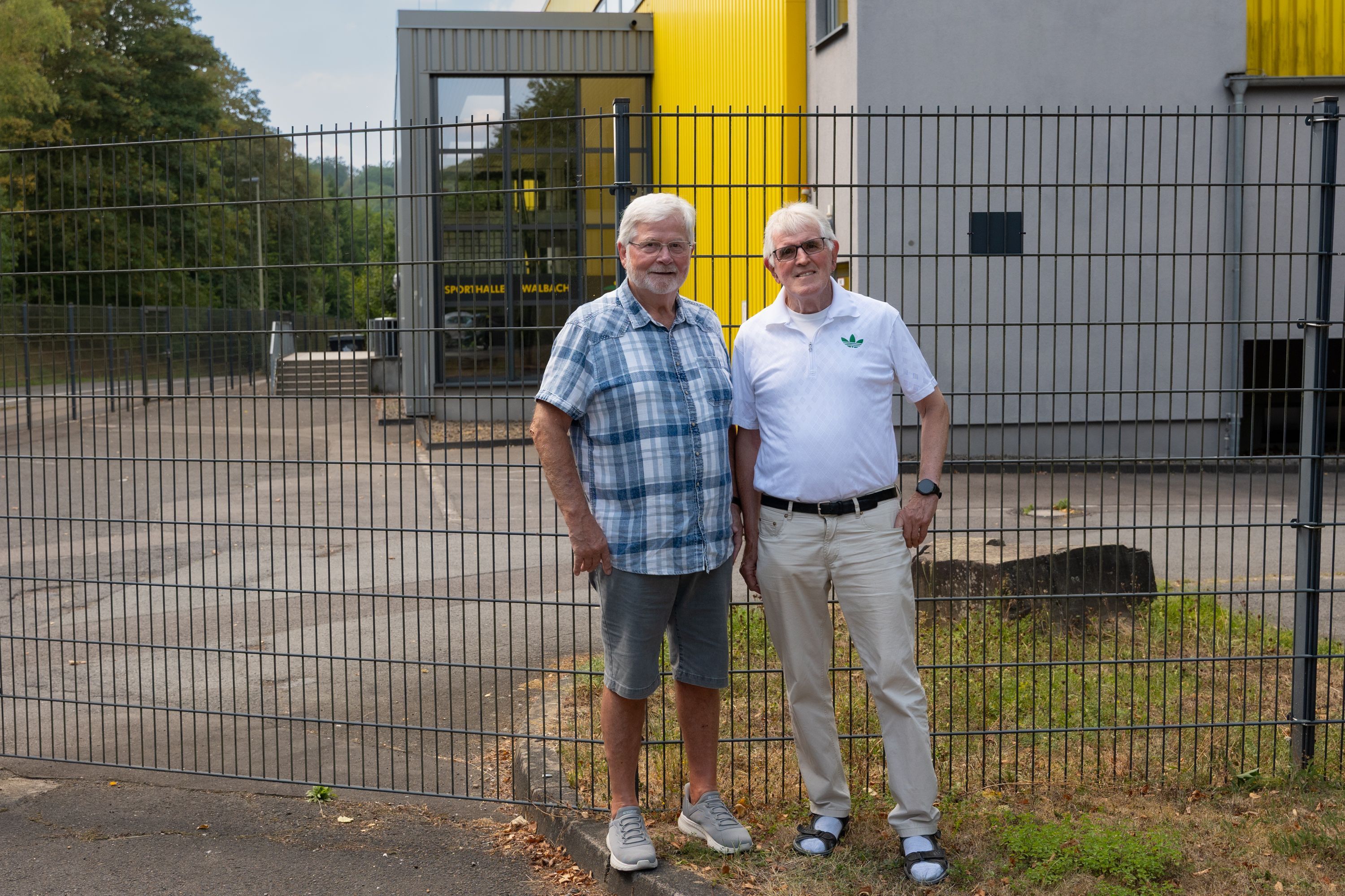 Die beiden Männer stehen vor dem Eingang der Halle.