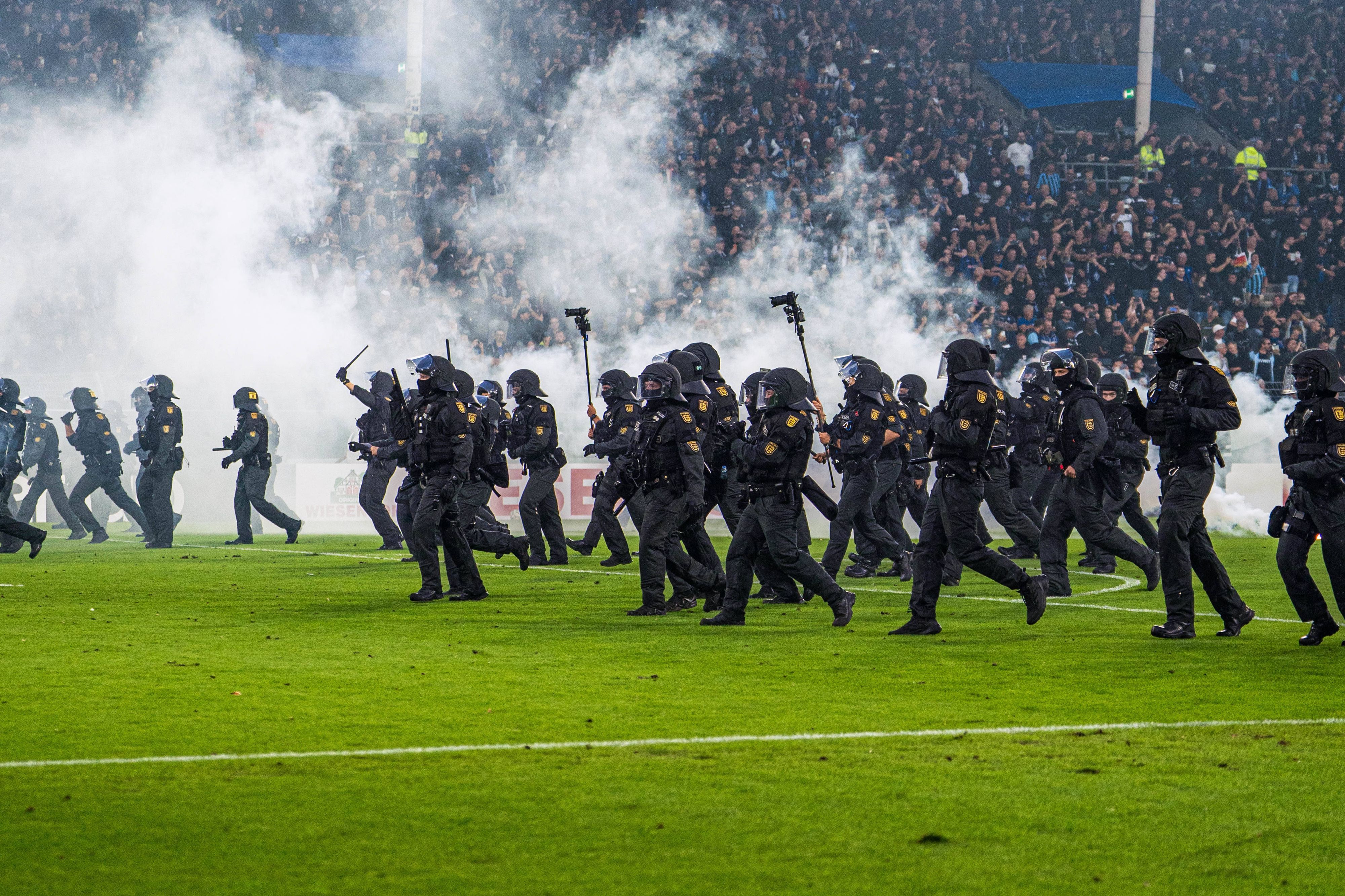 Polizisten stürmen auf den Platz.