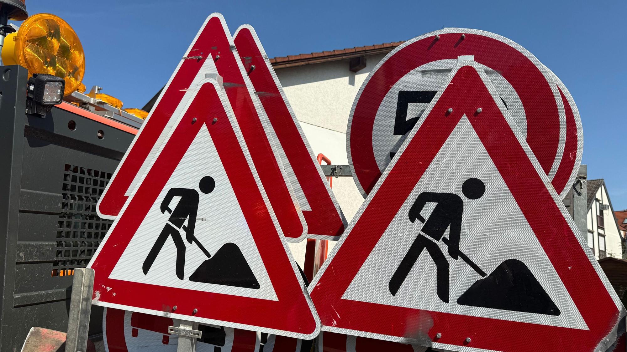 Mehrere Verkehrsschilder, die vor einer Baustelle warnen, stehen auf der Pritsche eines Transporters. (Symbolbild)