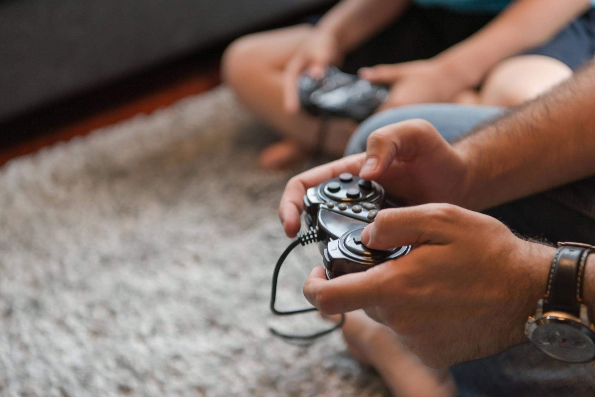 Happy family. Father, mother and children playing a video game Father and son playing video games together on the floor,model released, Symbolfoto PUBLICATIONxINxGERxSUIxAUTxONLY ING32193136131
