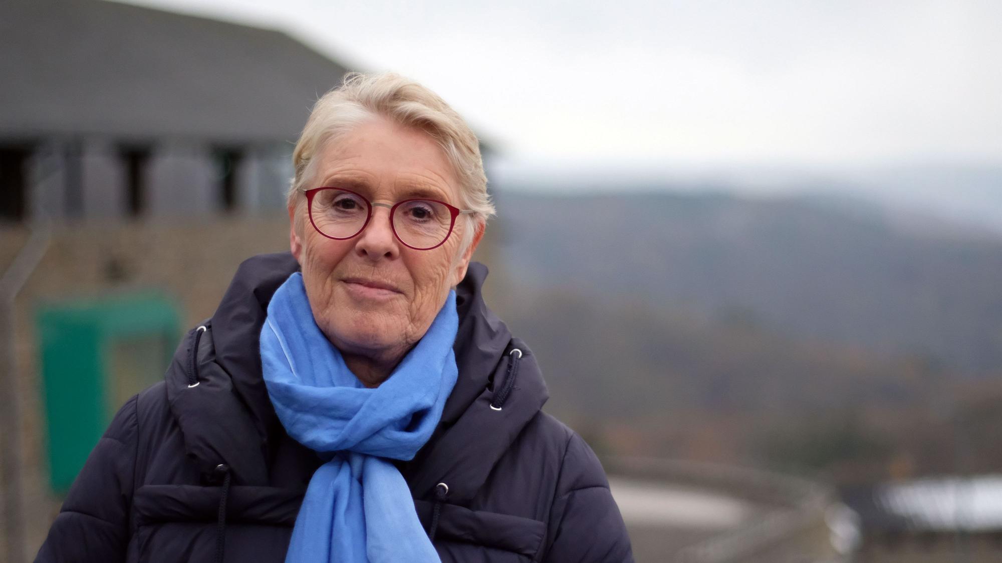 Hinter Anna-Maria Caspari ist leicht unscharf die Kulisse der Ordensburg Vogelsang zu sehen.