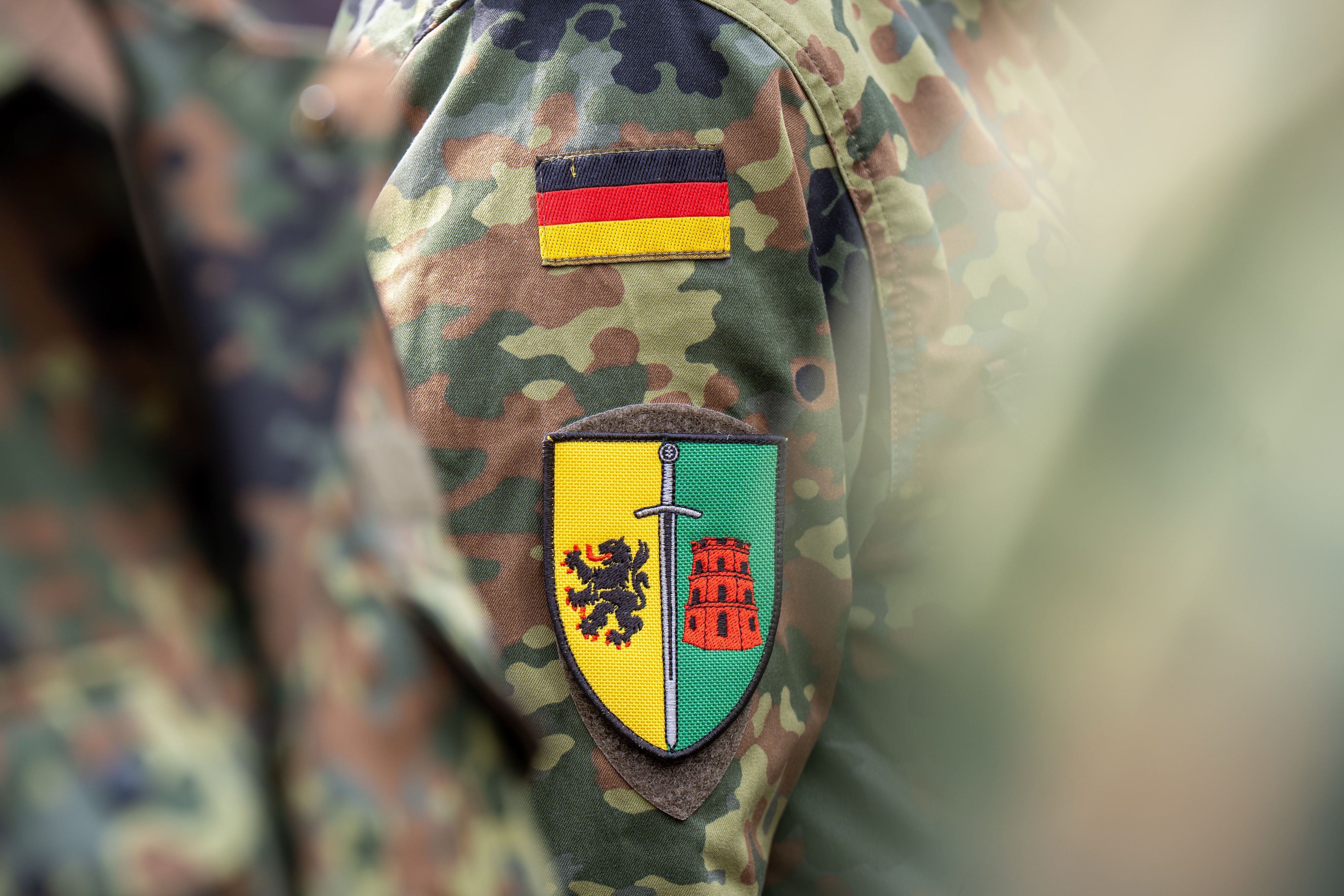 Ein Bundeswehrsoldat steht mit dem Patch der Litauen-Brigade beim Aufstellungsappell der Panzerbrigade 45 in der litauischen Hauptstadt.