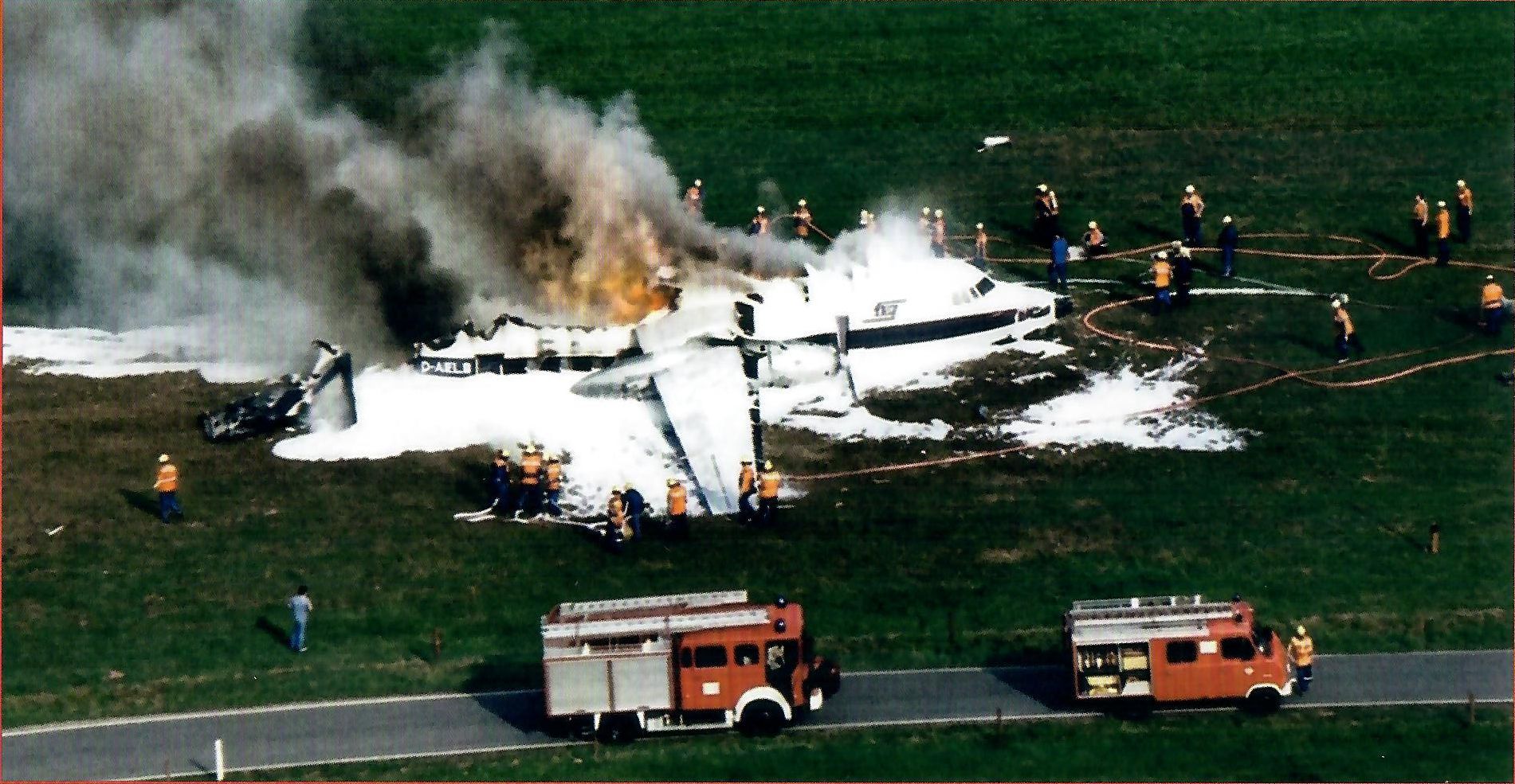 Feuerwehrwagen löschen ein brennendes Flugzeug.