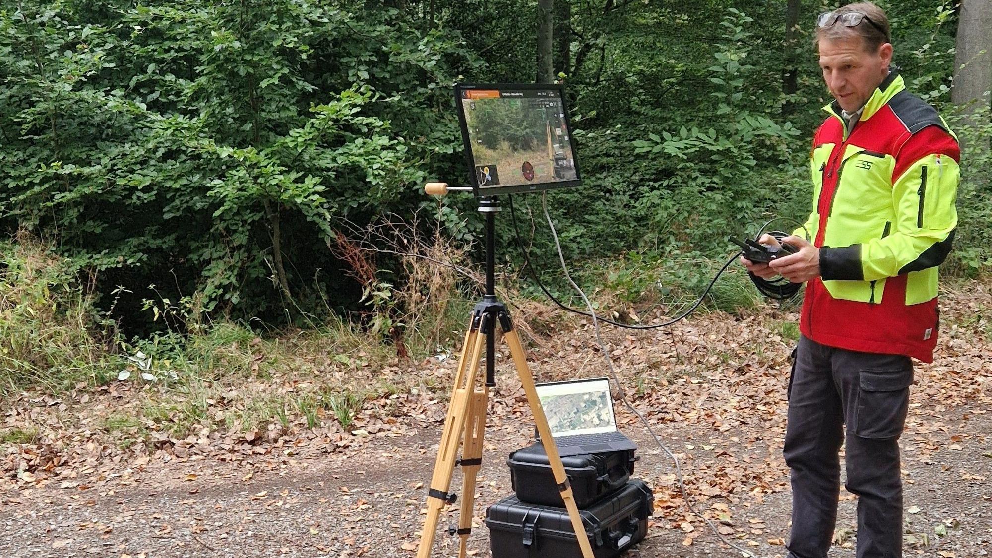 Stefan Lott vom Forstbetrieb Bad Münstereifel steuert eine Drohne. Das Bild, das sie überträgt, kann er auf einem Tablet-Bildschirm sehen.