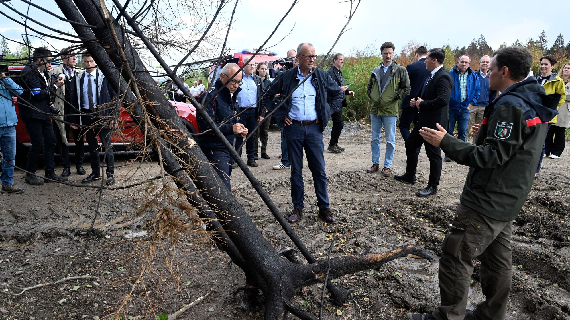 Forstbeamter Jan-Valentin Wiesmeyer (rechts) spricht mit Bundeskanzler Friedrich Merz.