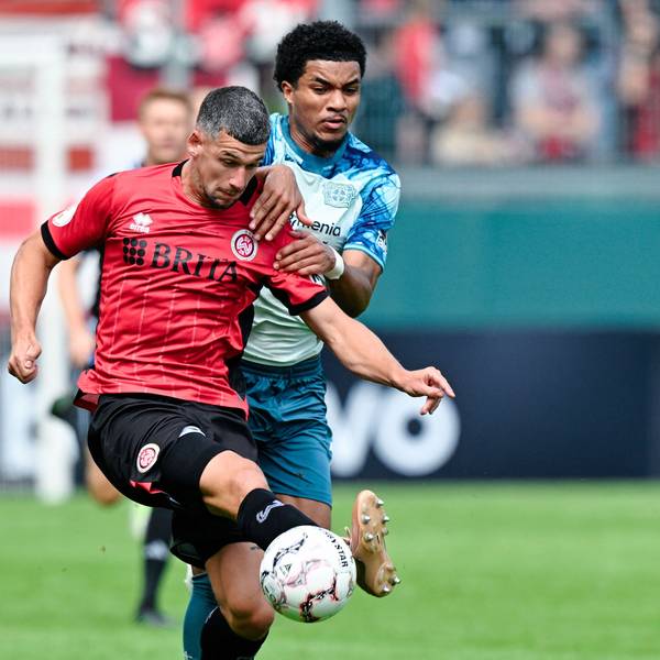 22.08.2026, Hessen, Wiesbaden: Fußball, Männer: DFB-Pokal, SV Wehen Wiesbaden - Bayer Leverkusen, 1. Runde, BRITA-Arena. Max Brandt (l, SV Wehen Wiesbaden) und Malik Tillmann (Bayer 04 Leverkusen) kämpfen um den Ball. Foto: Uwe Anspach/dpa - WICHTIGER HINWEIS: Gemäß den Vorgaben der Bundesliga bzw. des DFB Deutscher Fußball-Bund ist es untersagt, in dem Stadion und/oder vom Spiel angefertigte Fotoaufnahmen in Form von Sequenzbildern und/oder videoähnlichen Fotostrecken zu verwerten bzw. verwerten zu lassen. +++ dpa-Bildfunk +++