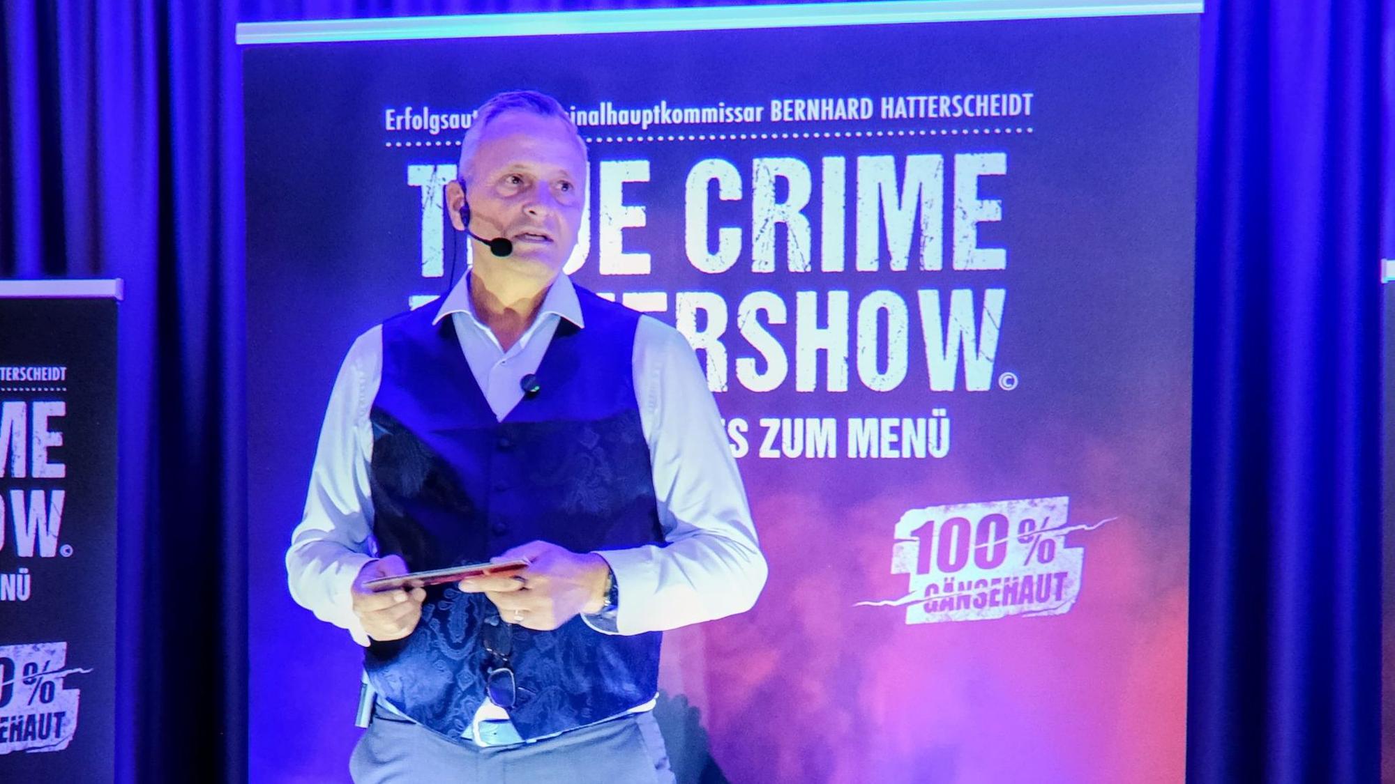 Bernhard Hatterscheidt steht auf einer kleinen Bühne.