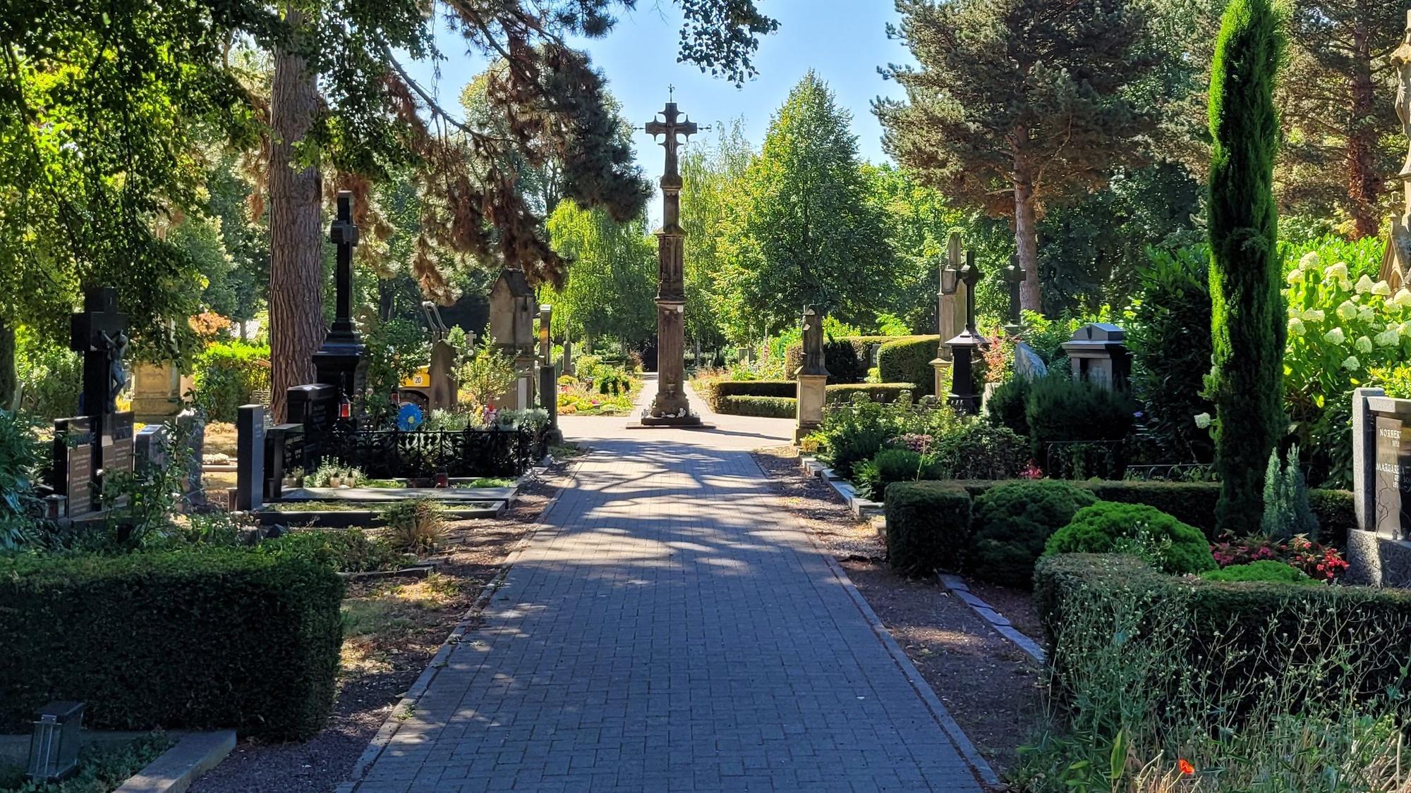 Blick auf die zentrale Allee des Brauweiler Friedhofs mit vielen alten Gräbern.