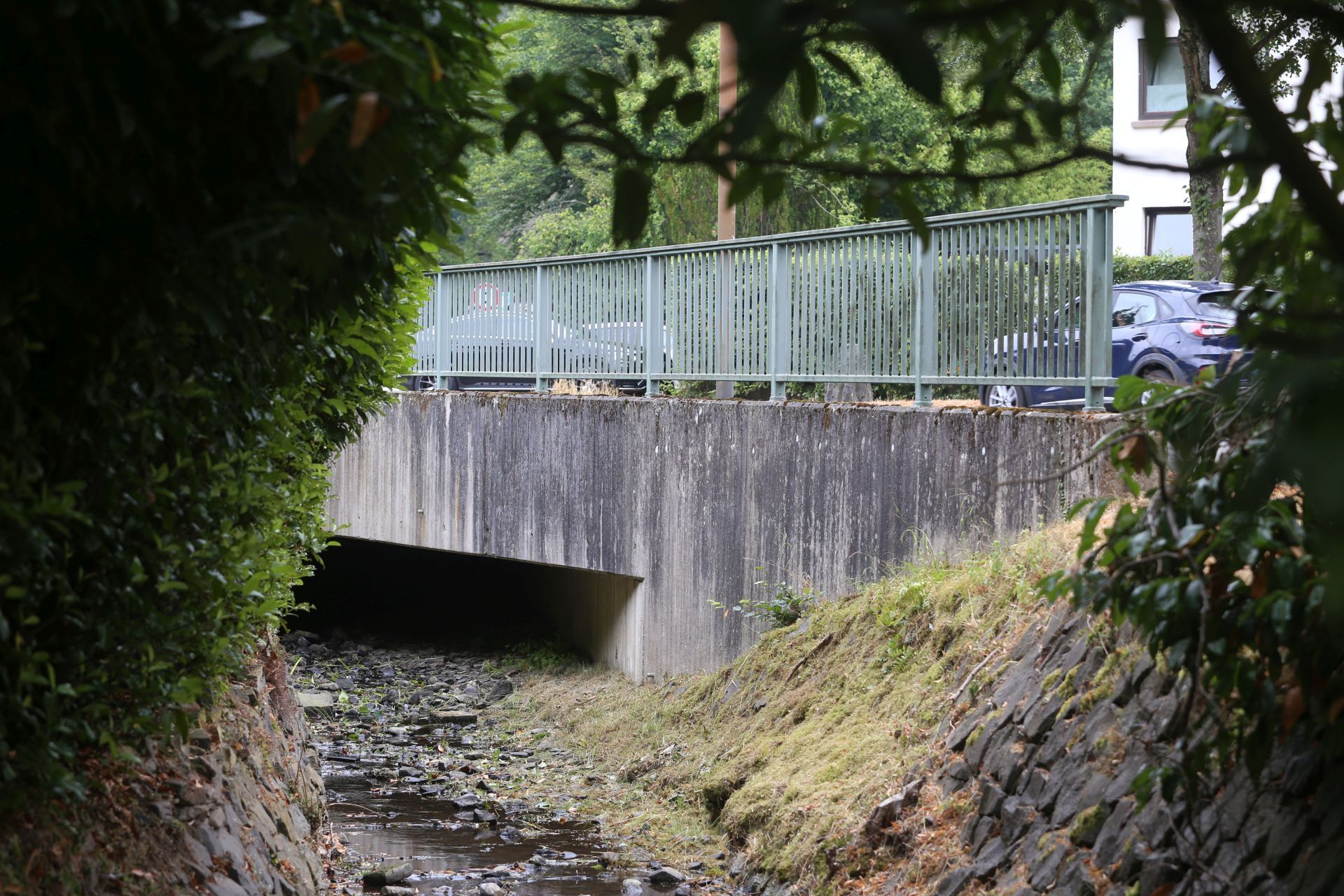 Eine Betonbrücke über einem kleinen Bach.
