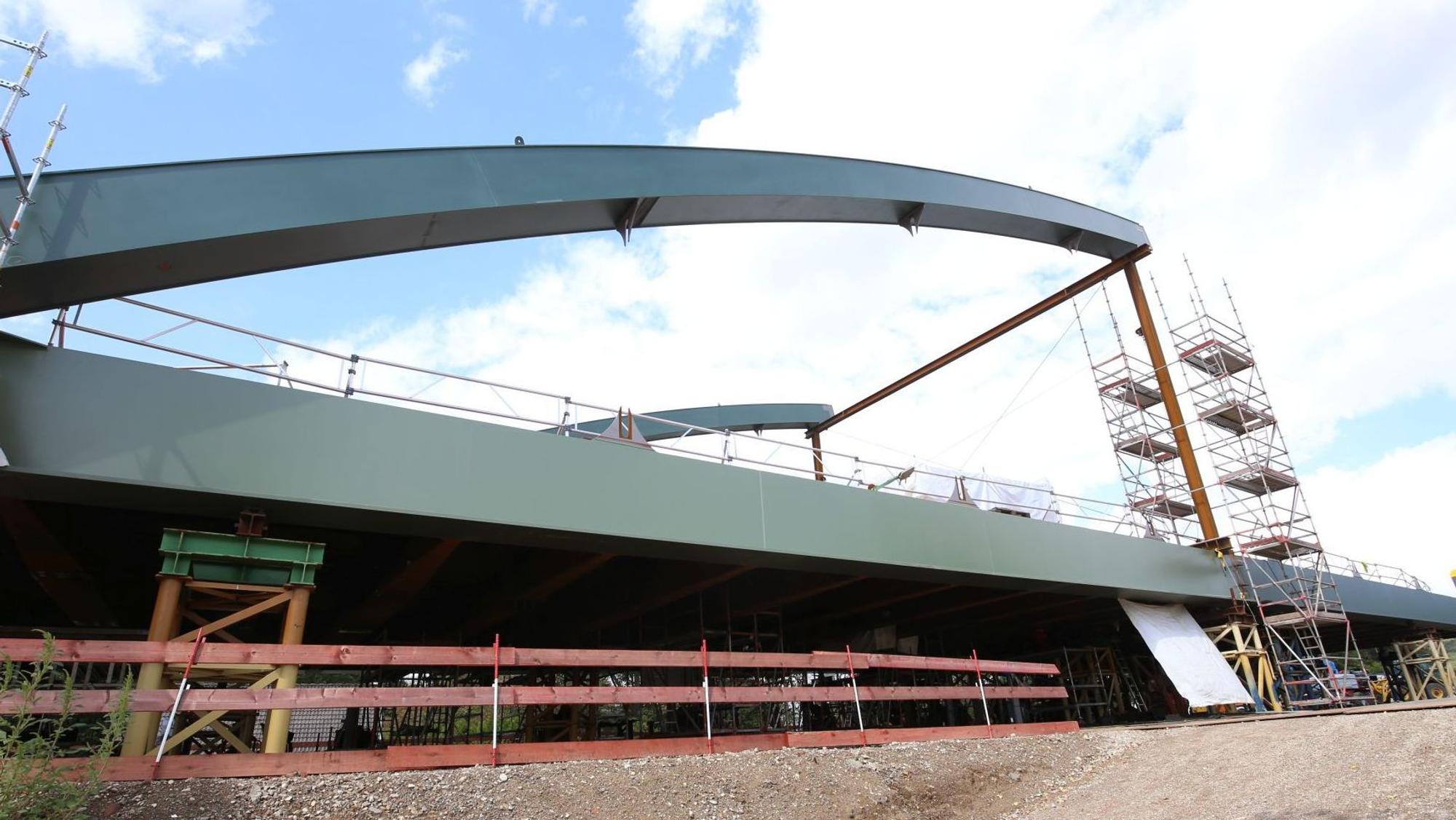 Eine etwa zur Hälfte vormontierte Stahl-Stabbogenbrücke.