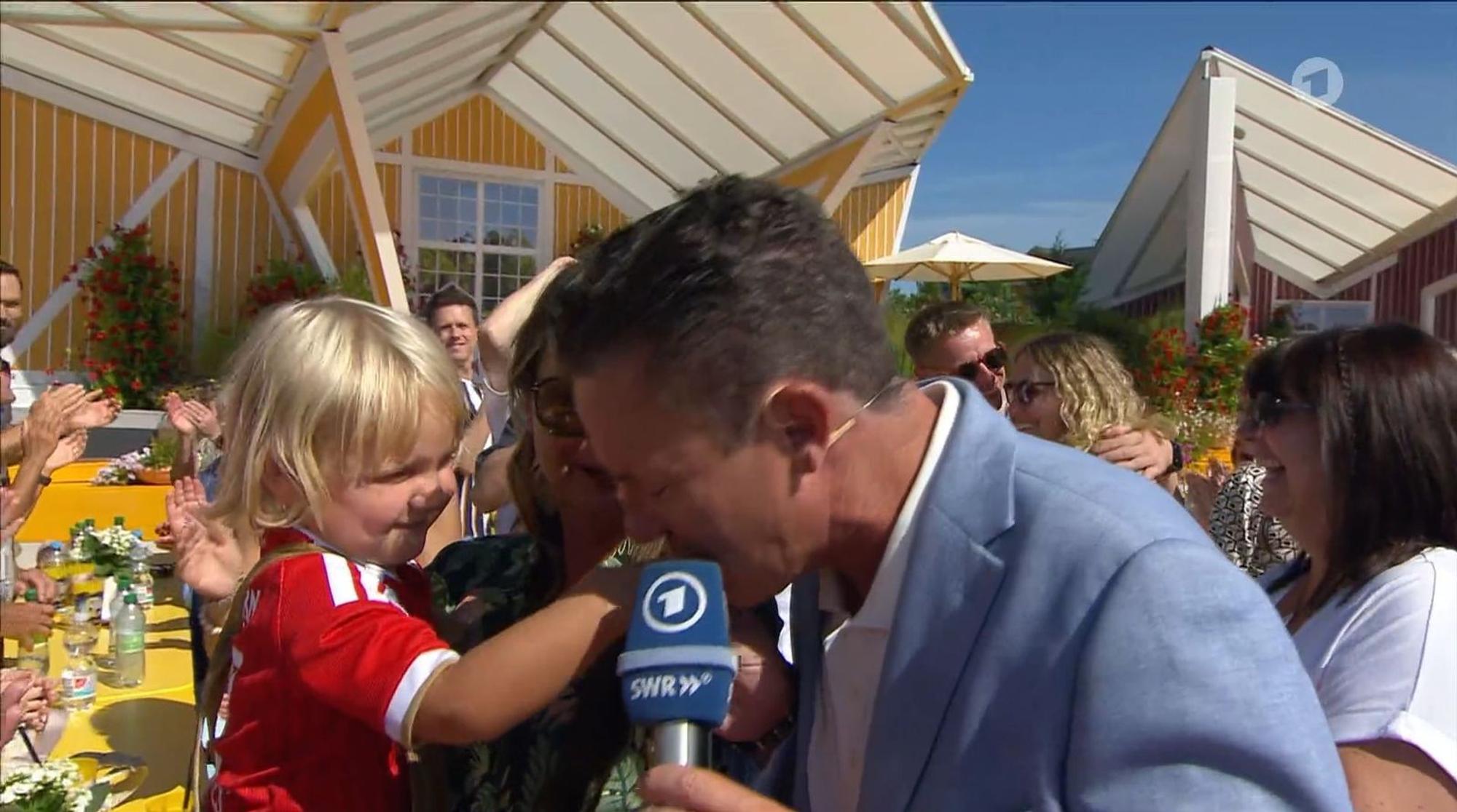 Niedlicher Moment: Stefan Mross gab dem Kind auf Eva Lugingers Arm einen Kuss auf die Hand. (Bild: ARD)