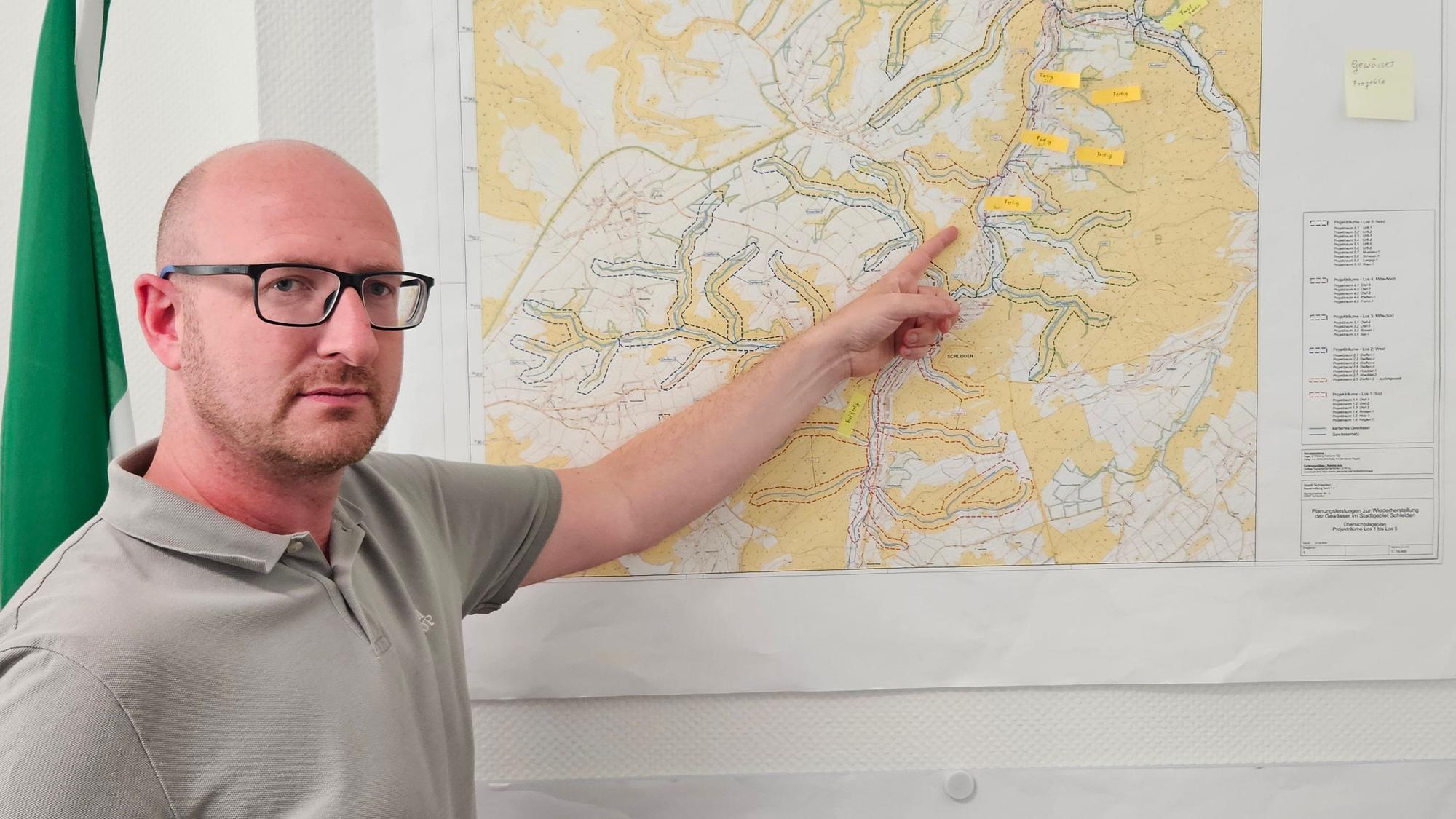 Bürgermeister Ingo Pfennings deutet mit ausgestrecktem Arm auf eine Karte.