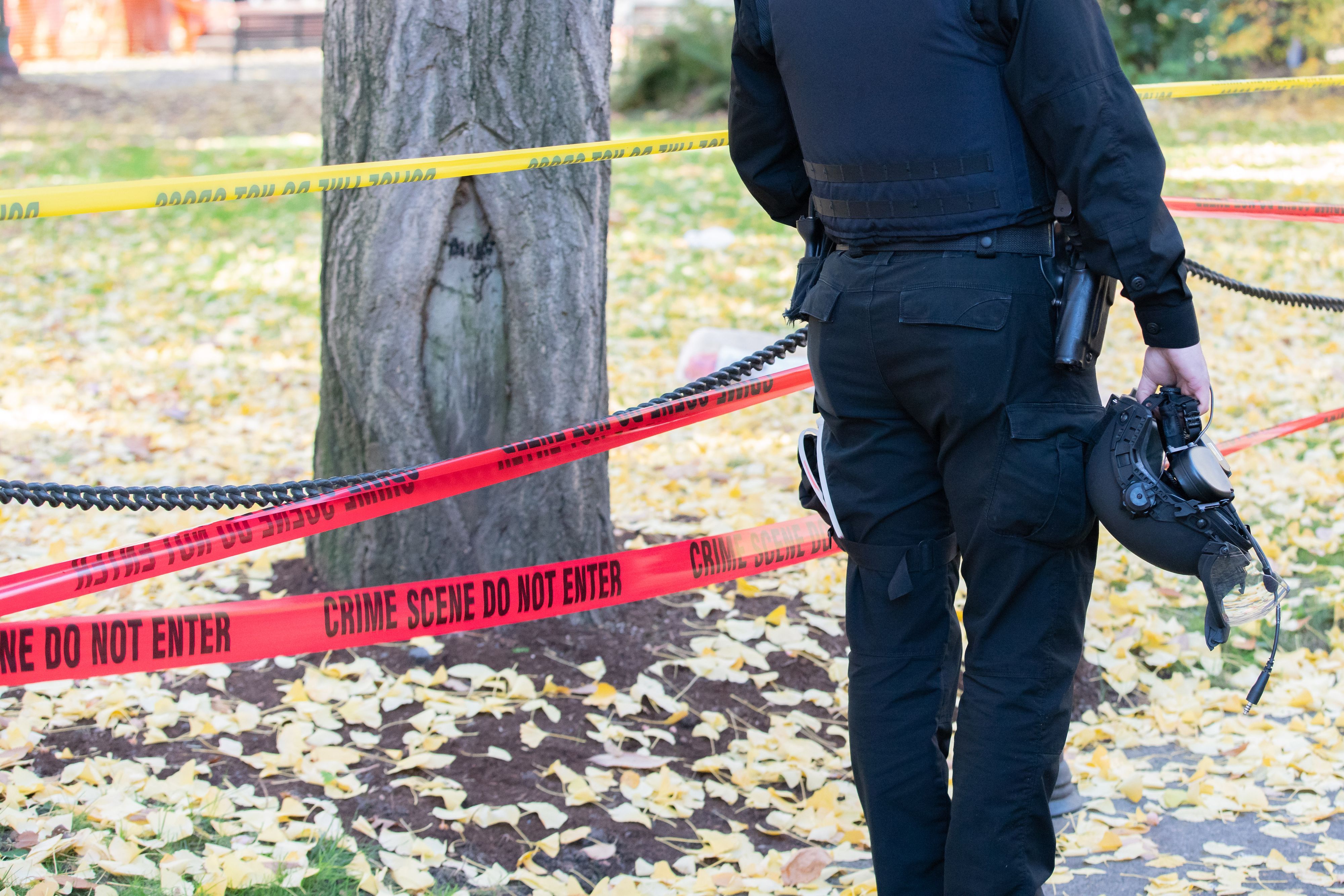 Polizist mit Helm, der am Tatort steht.