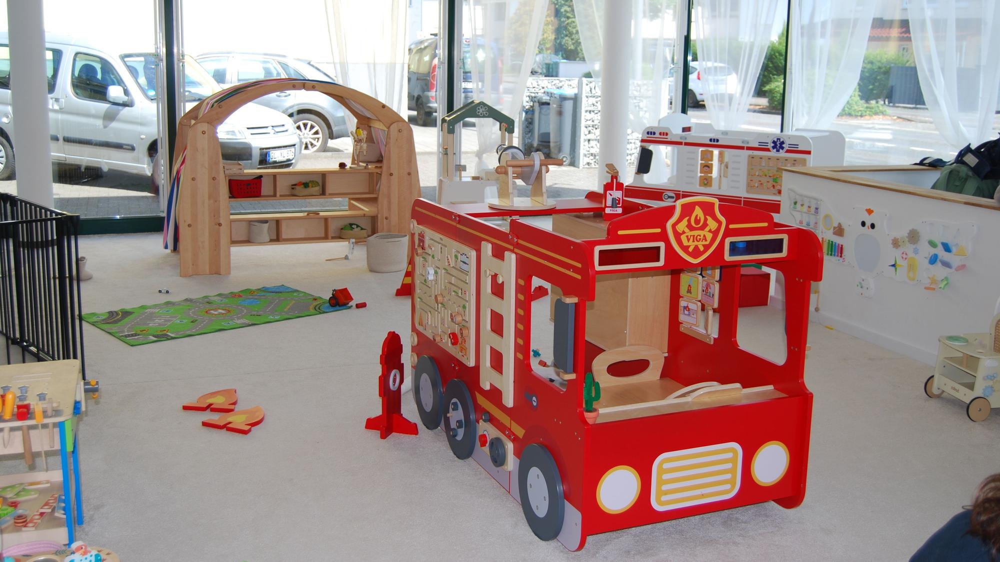 Zu sehen sind diverse Spielsachen, darunter ein Feuerwehrauto.