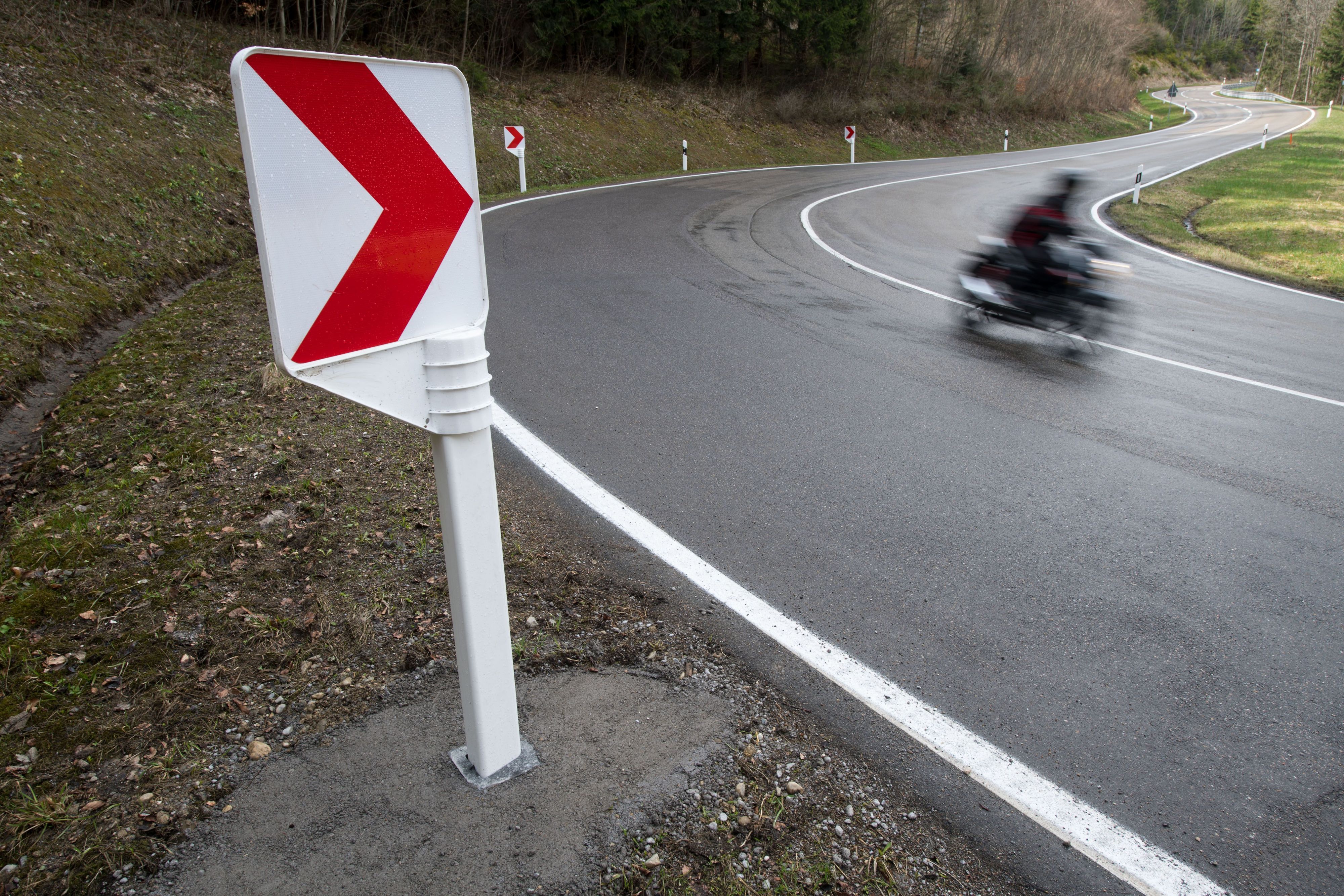 Ein Motorradfahrer fährt durch eine Serpentine.