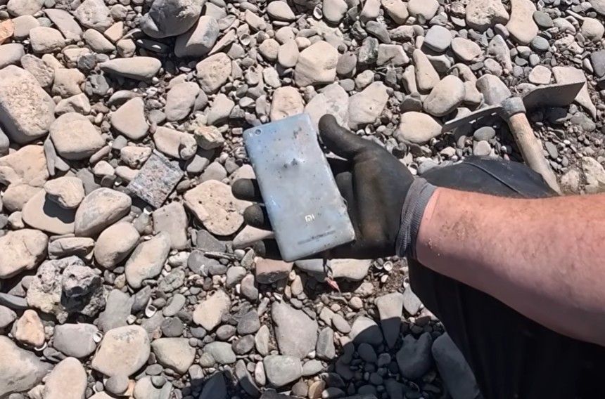 Der „German Treasure Hunter“ hält ein altes Handy in der Hand.