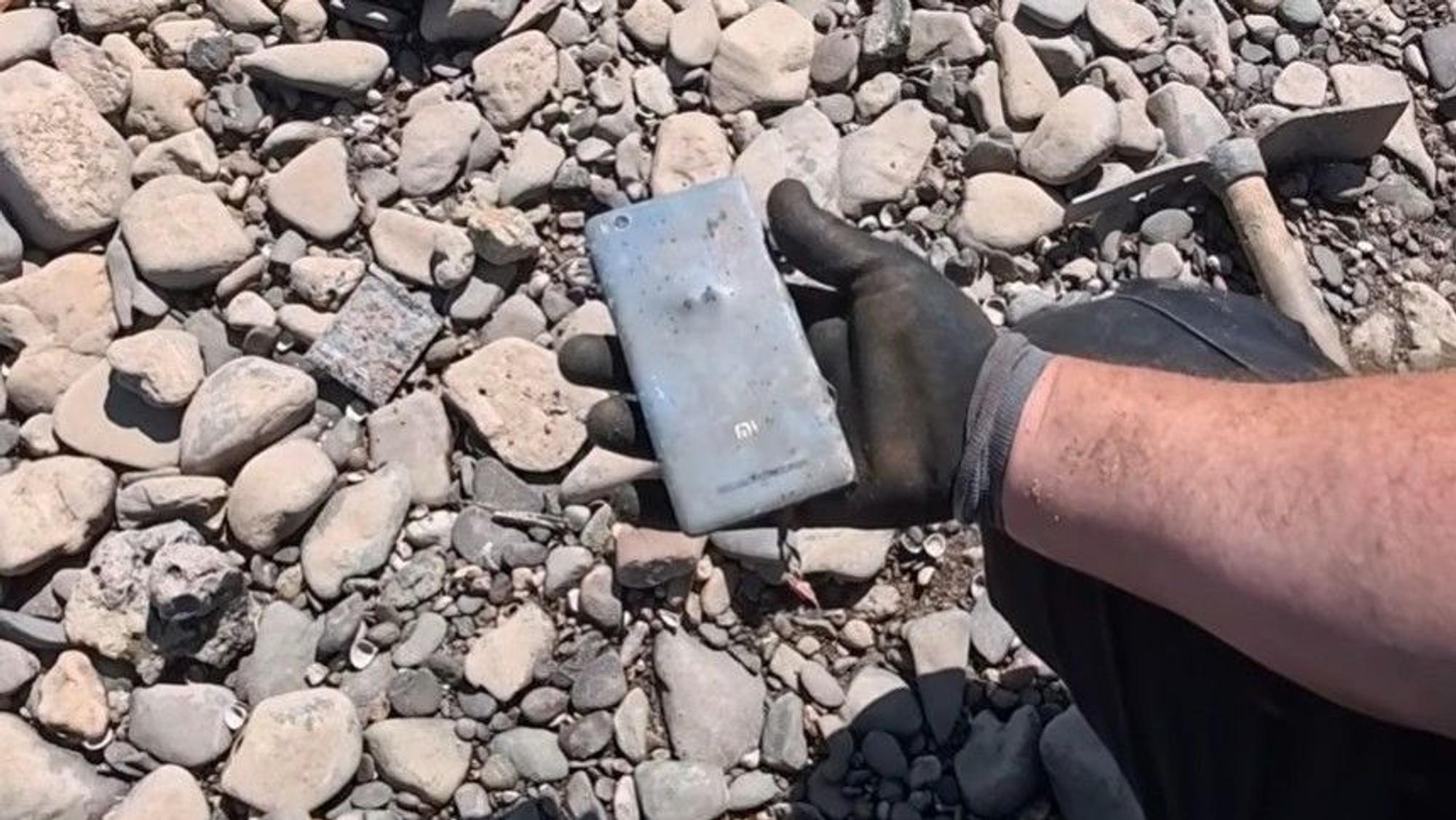 Der „German Treasure Hunter“ hält ein altes Handy in der Hand.
