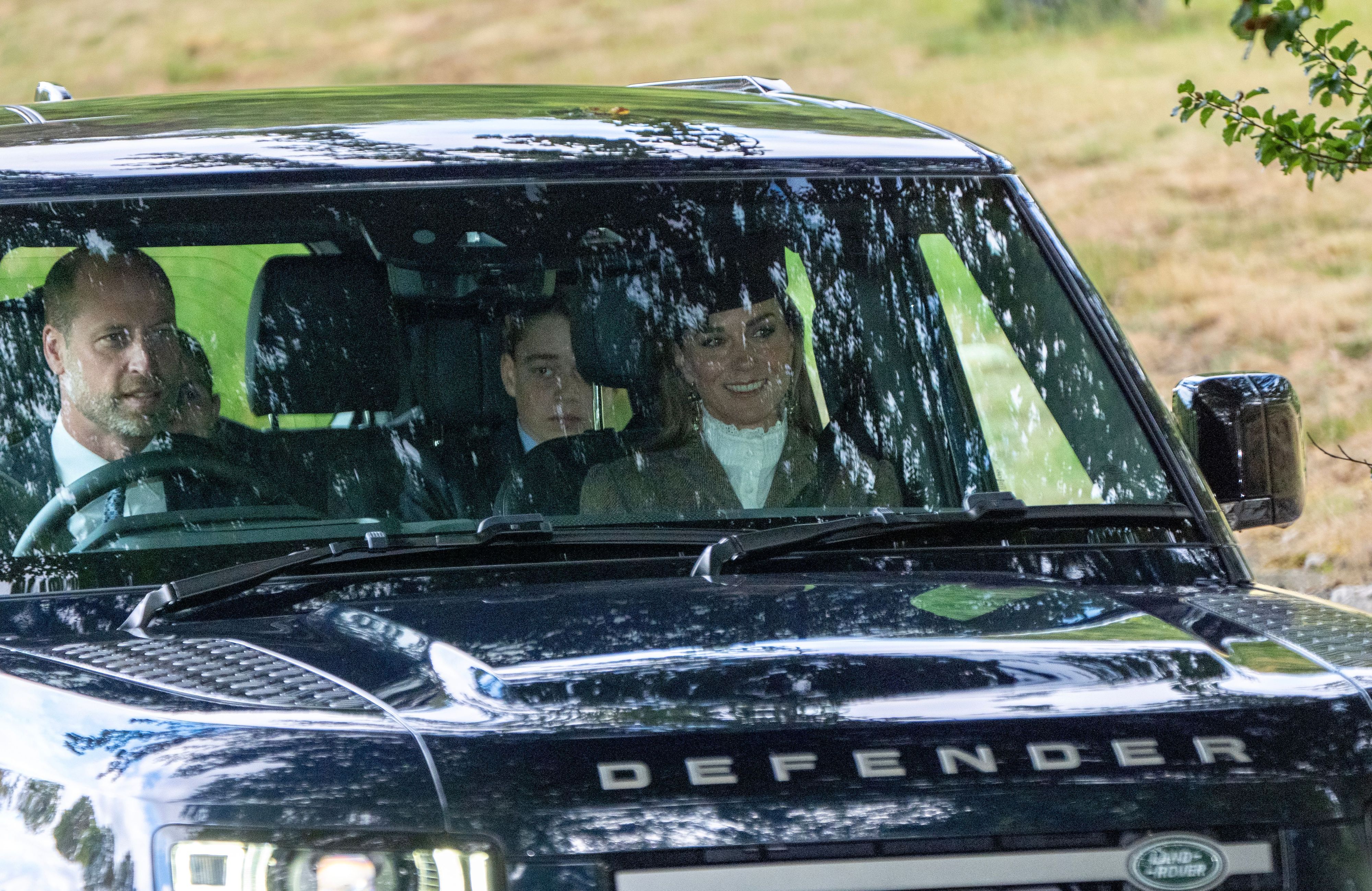 Der Prinz und die Prinzessin von Wales sowie ihr Sohn Prinz George und ihre Tochter Prinzessin Charlotte (links, teilweise verdeckt) treffen ein, um an einem Sonntagsgottesdienst in der Crathie Kirk in der Nähe von Balmoral teilzunehmen.