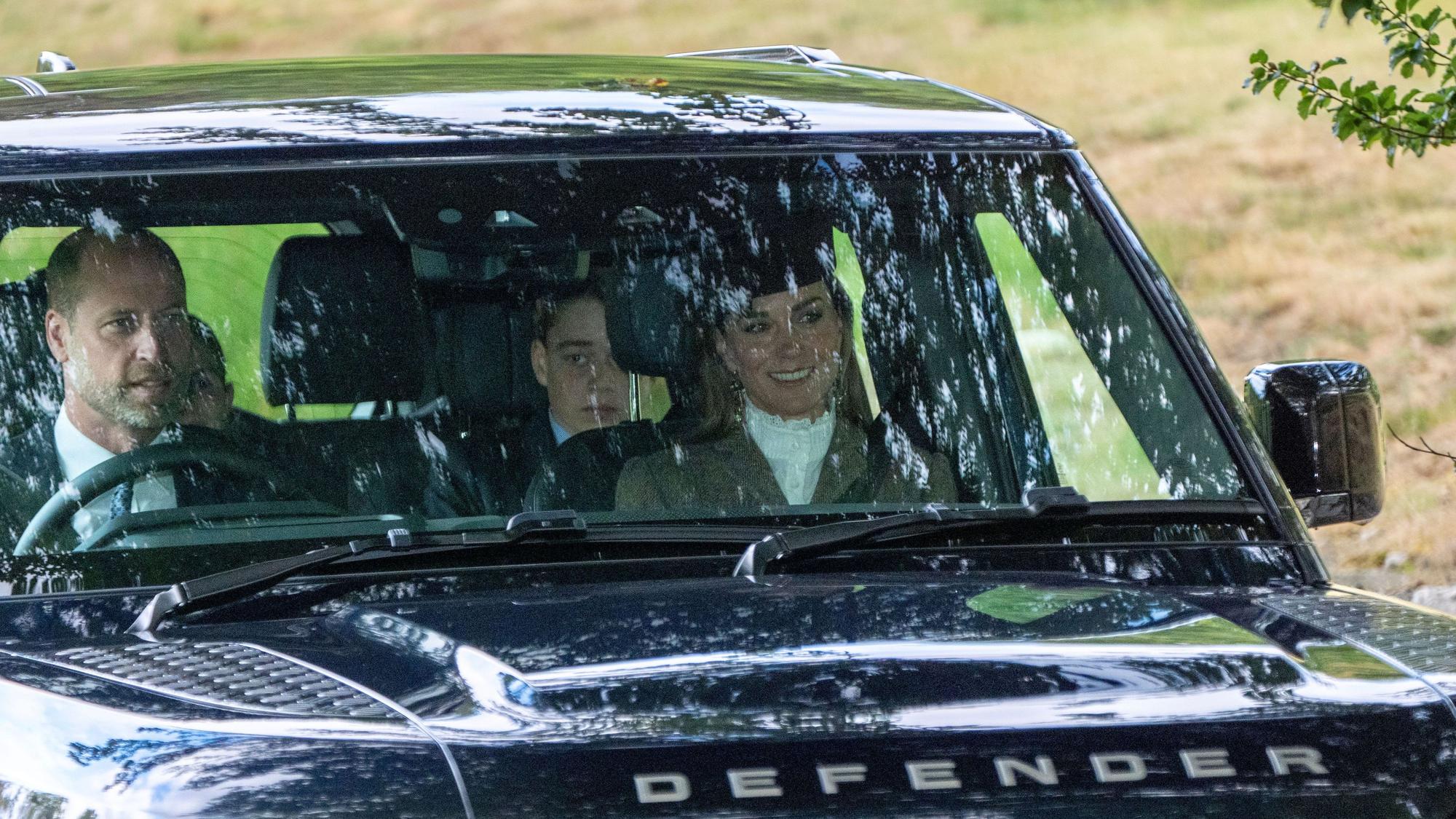 Der Prinz und die Prinzessin von Wales sowie ihr Sohn Prinz George und ihre Tochter Prinzessin Charlotte (links, teilweise verdeckt) treffen ein, um an einem Sonntagsgottesdienst in der Crathie Kirk in der Nähe von Balmoral teilzunehmen.