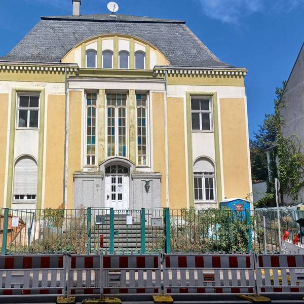 Auf dem Grundstück einer herrschaftlichen Villa stehen Baucontainer und ein Dixi-Klo.