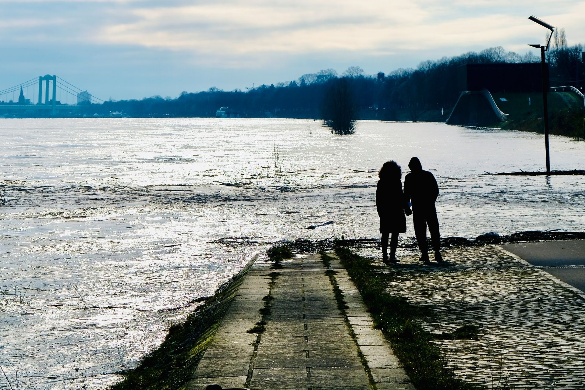 Ein Paar steht an einer vom Rhein überspülten Rampe.