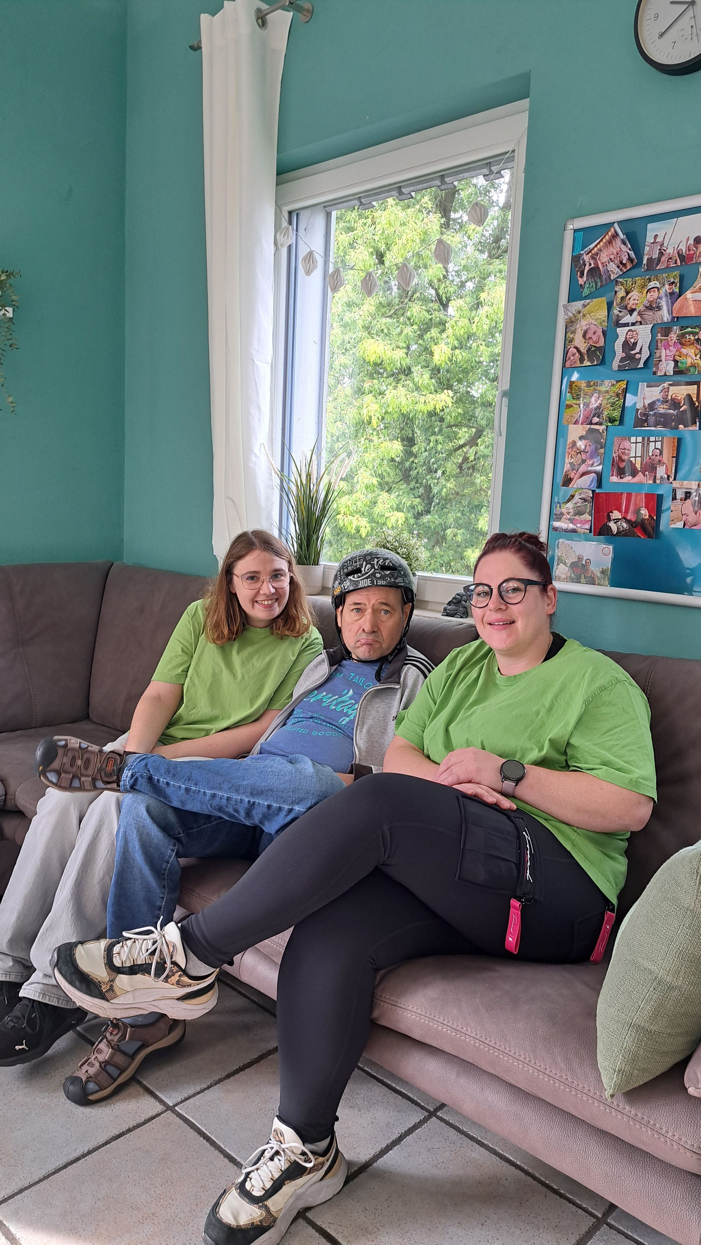 Das Foto zeigt drei Personen auf einem Sofa.