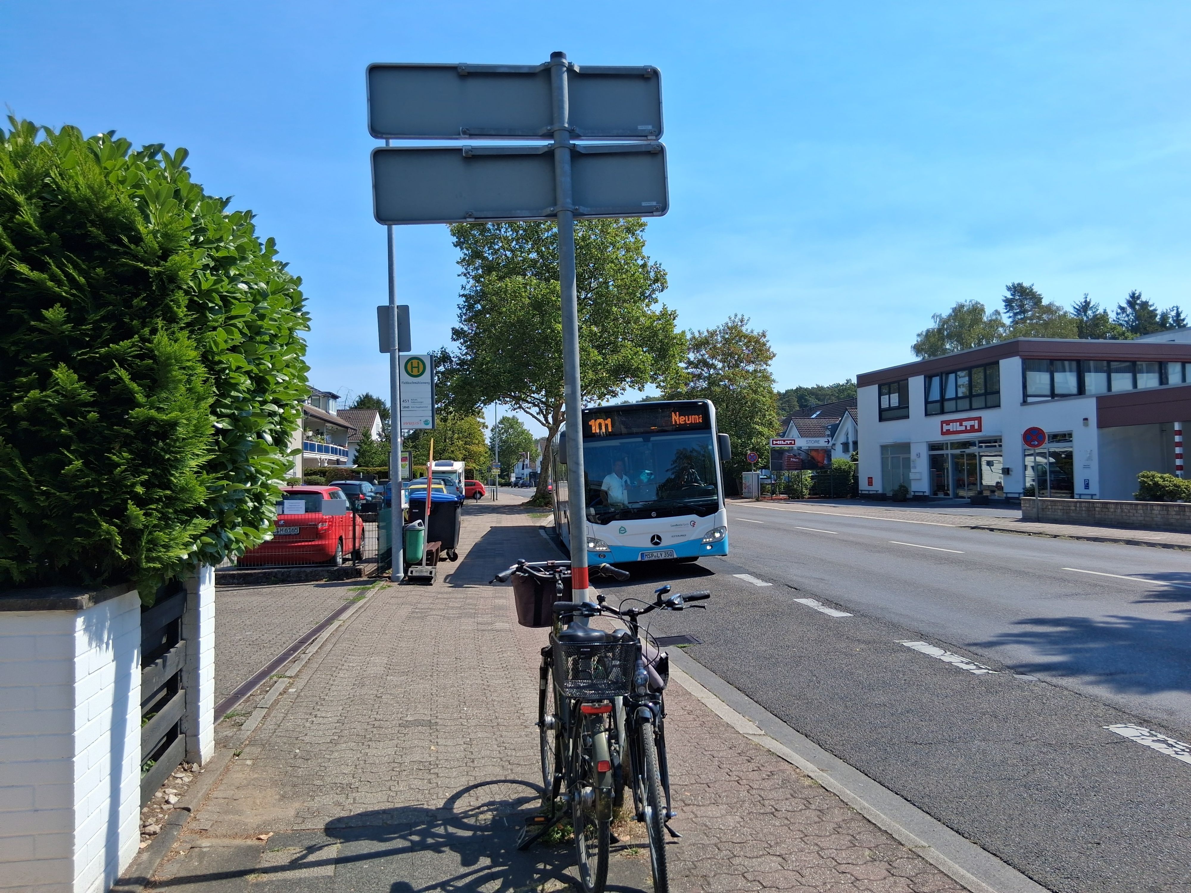 Zu sehen ist ein Bus auf einer Straße, die Sonne scheint.