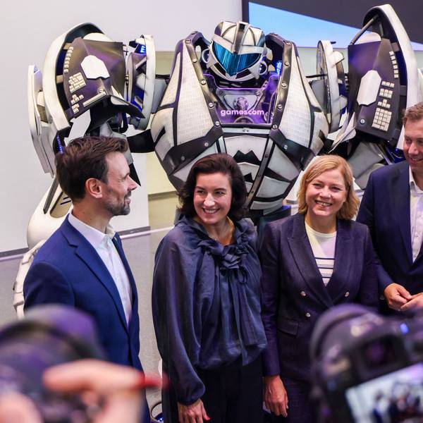 Felix Falk, Dorothee Bär, Henna Virkkunen und Lars Klingbeil stehen zur Eröffnung der Messe Gamescom vor einem Transformer-Roboter.