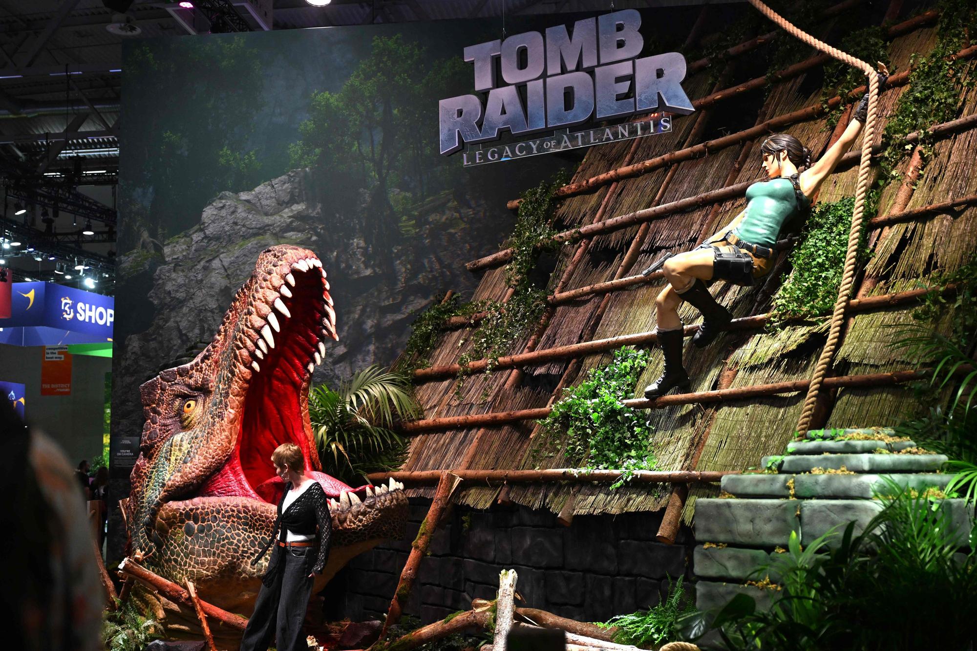 Ein Besucher posiert auf dem Kölner Messegelände vor dem Videospiel „Tomb Raider: Legacy of Atlantis“ von Crystal Dynamics und Flying Wild Hog.