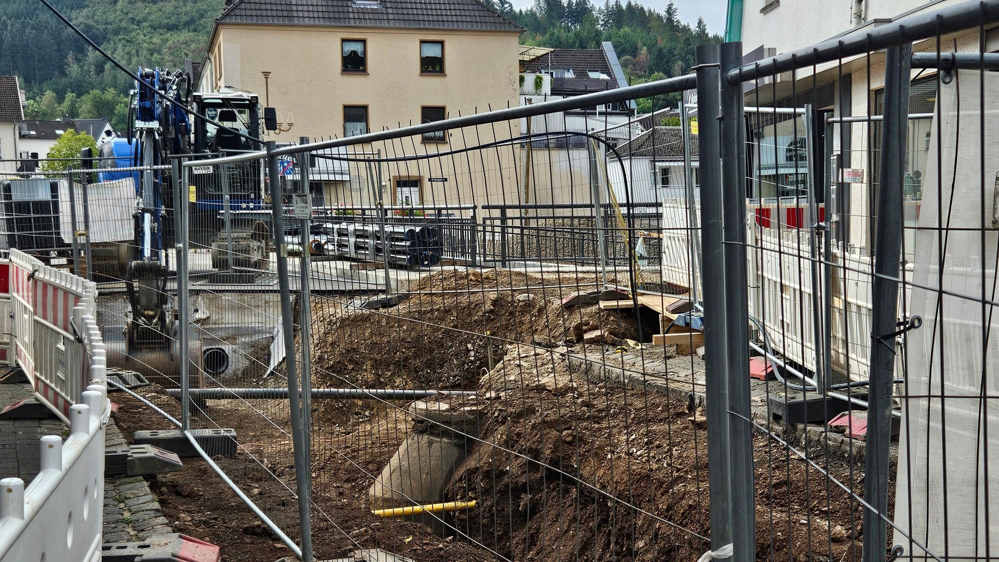 Zu sehen sind die aufgerissene Straße vor der Brücke und ein Bagger.