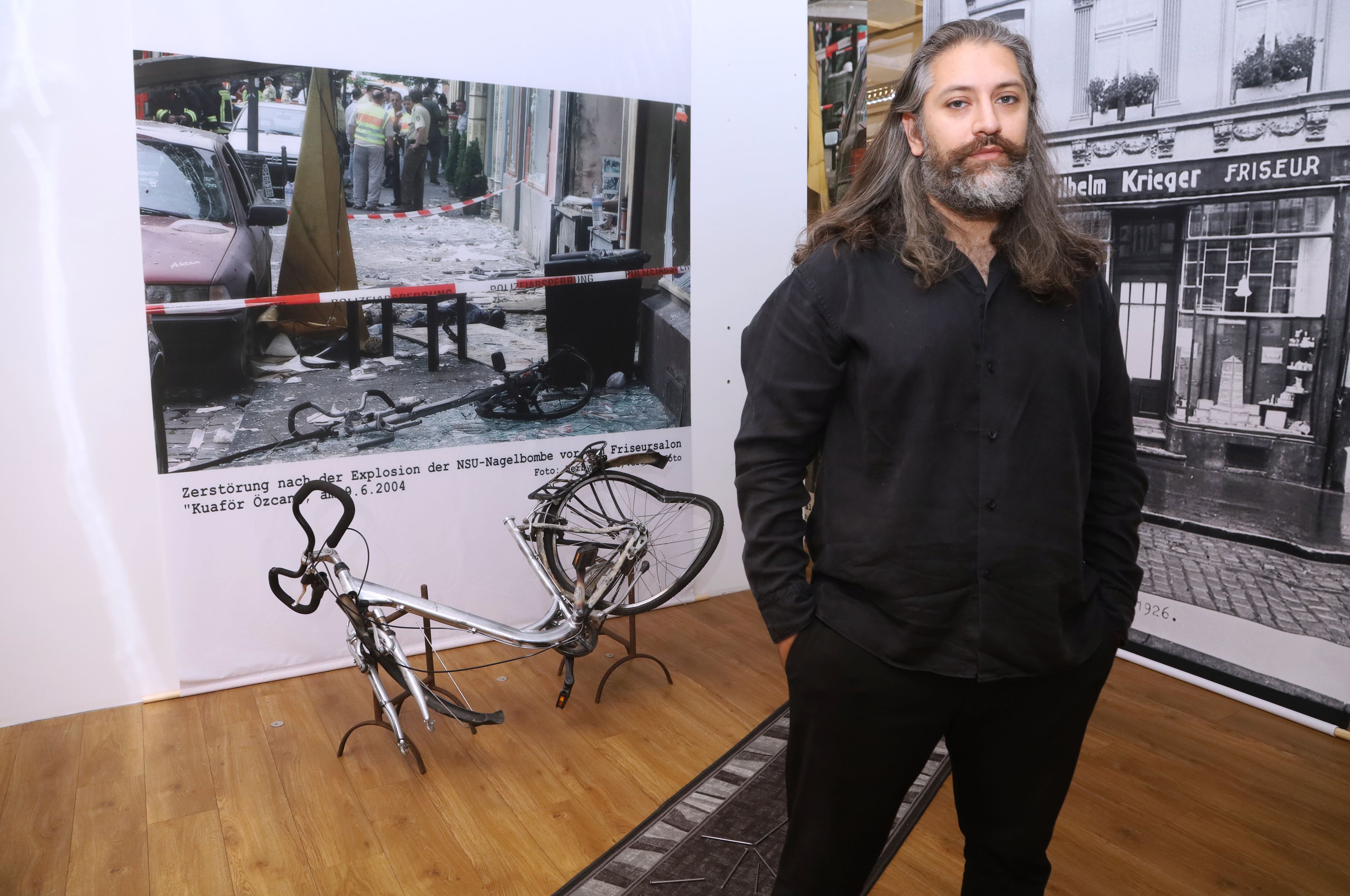 Hüseyin Topel, Vorsitzender der Bildungsinitiative, vor der Nachbildung des demolierten Fahrrads, auf dem die Nagelbombe platziert war.
