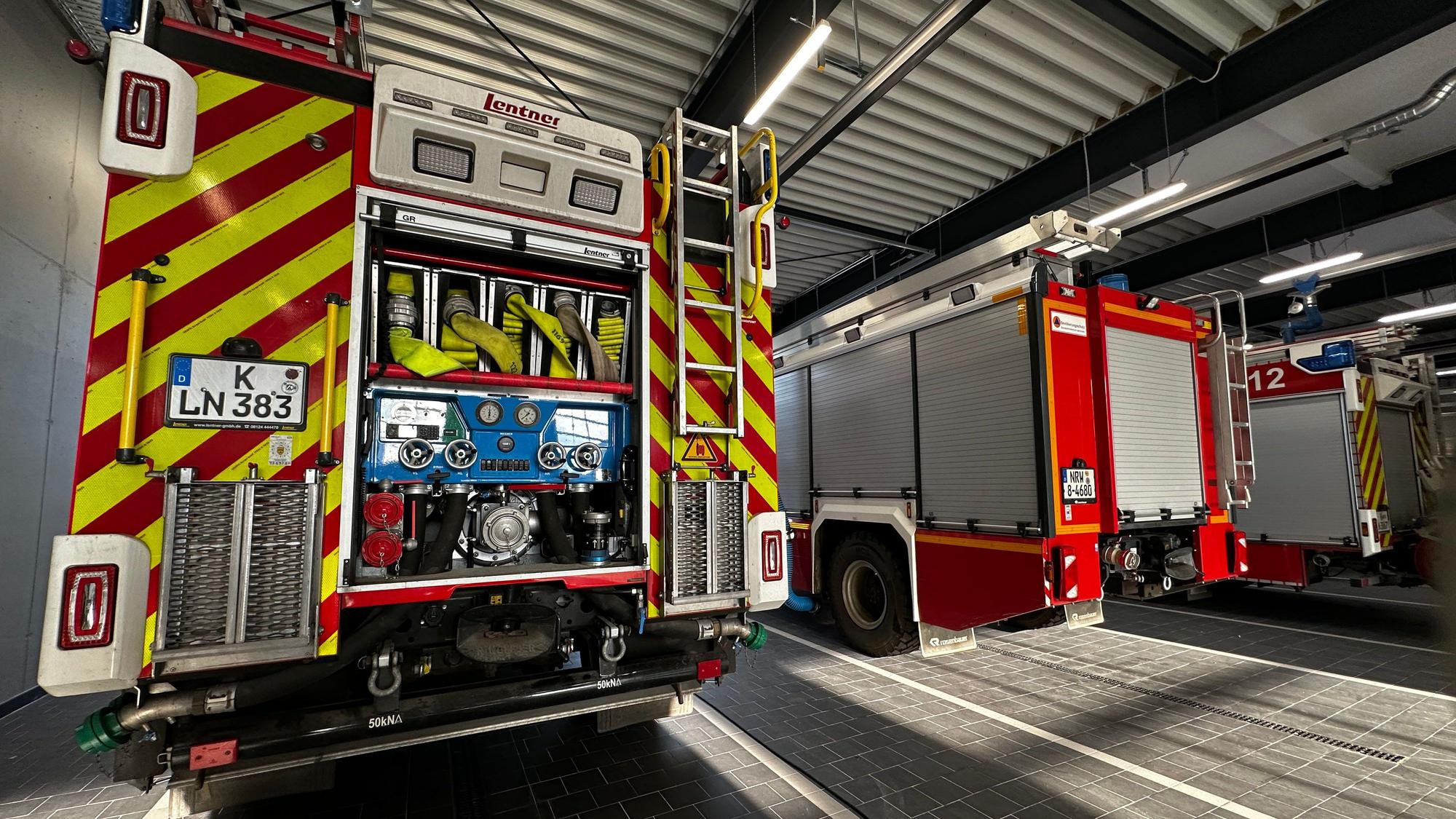 Drei Feuerwehrfahrzeuge stehen nebeneinander in dem neuen Gebäude der Feuerwache Rodenkirchen.