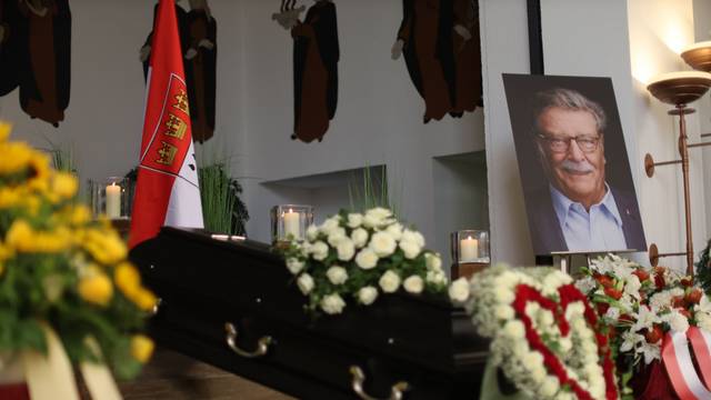 Ein Herz aus Blumen und zahlreiche Kränze umgeben den Sarg von Fritz Schramma.