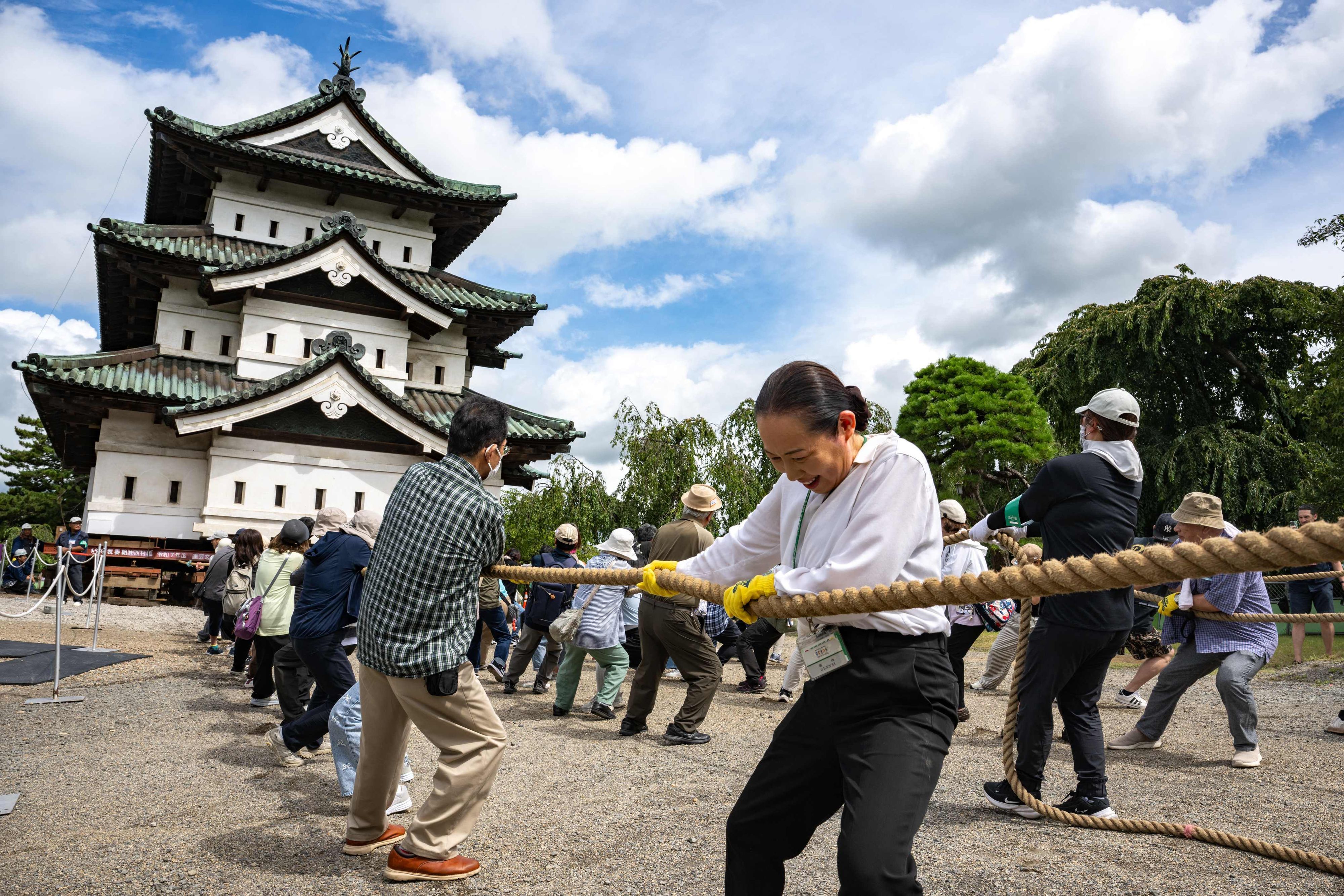 Nach den Restaurierungsarbeiten in Hirosaki in der Präfektur Aomori ziehen Freiwillige am 26. August 2026 einen Teil der Burg Hirosaki mit Seilen an ihren ursprünglichen Standort zurück.