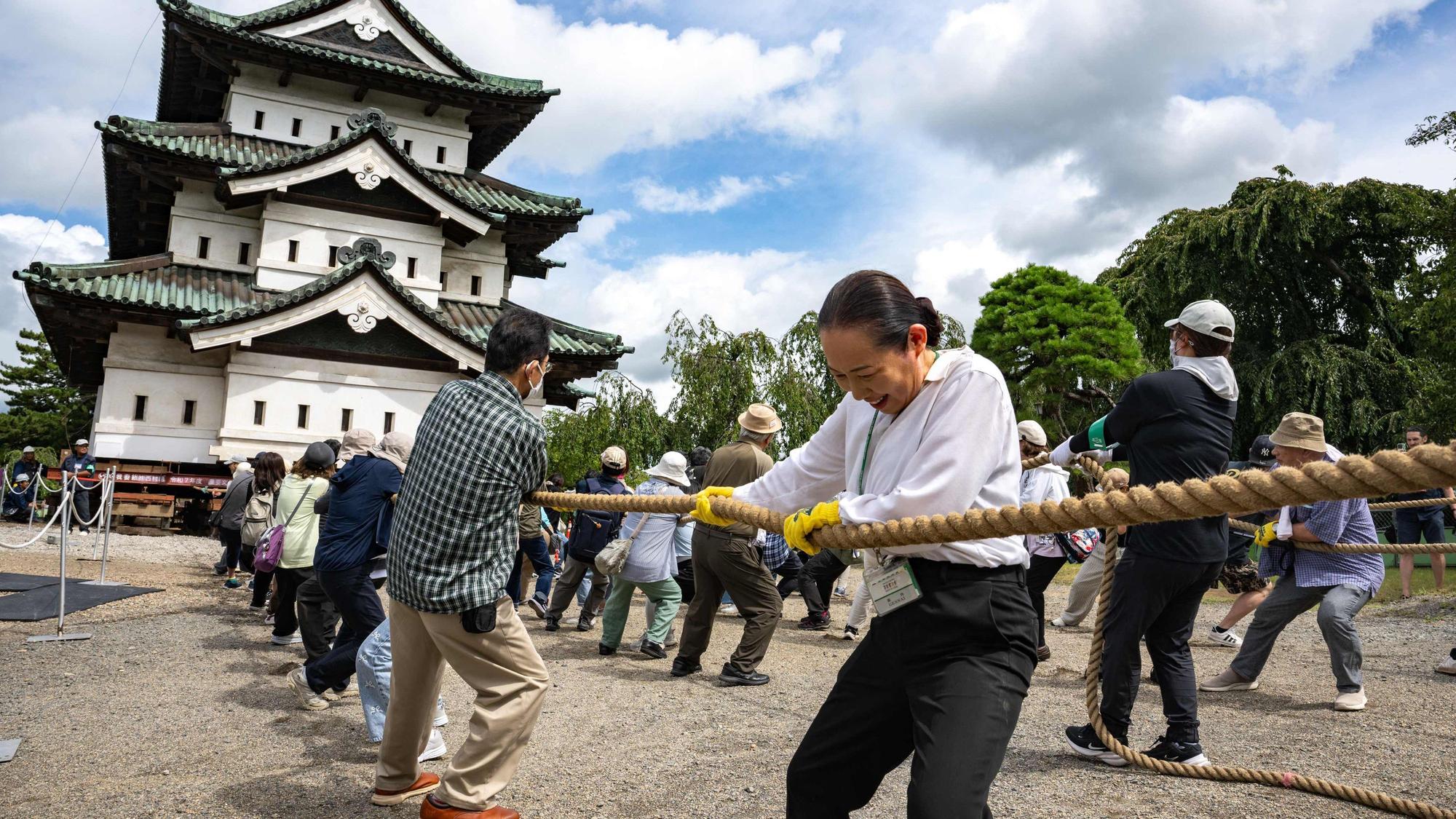 Nach den Restaurierungsarbeiten in Hirosaki in der Präfektur Aomori ziehen Freiwillige am 26. August 2026 einen Teil der Burg Hirosaki mit Seilen an ihren ursprünglichen Standort zurück.