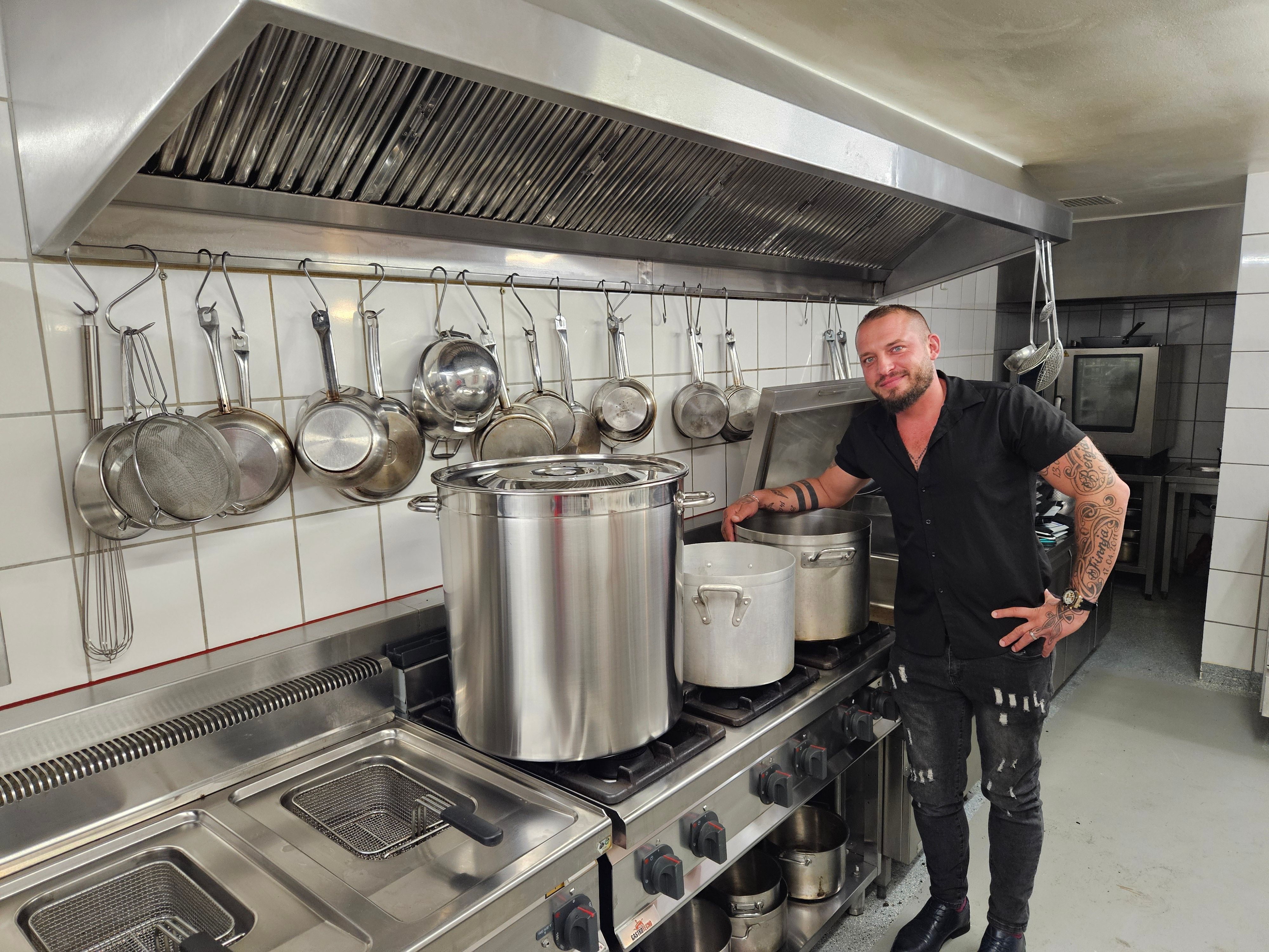 Maik Biedermann steht am Herd mit drei großen Kesseln.