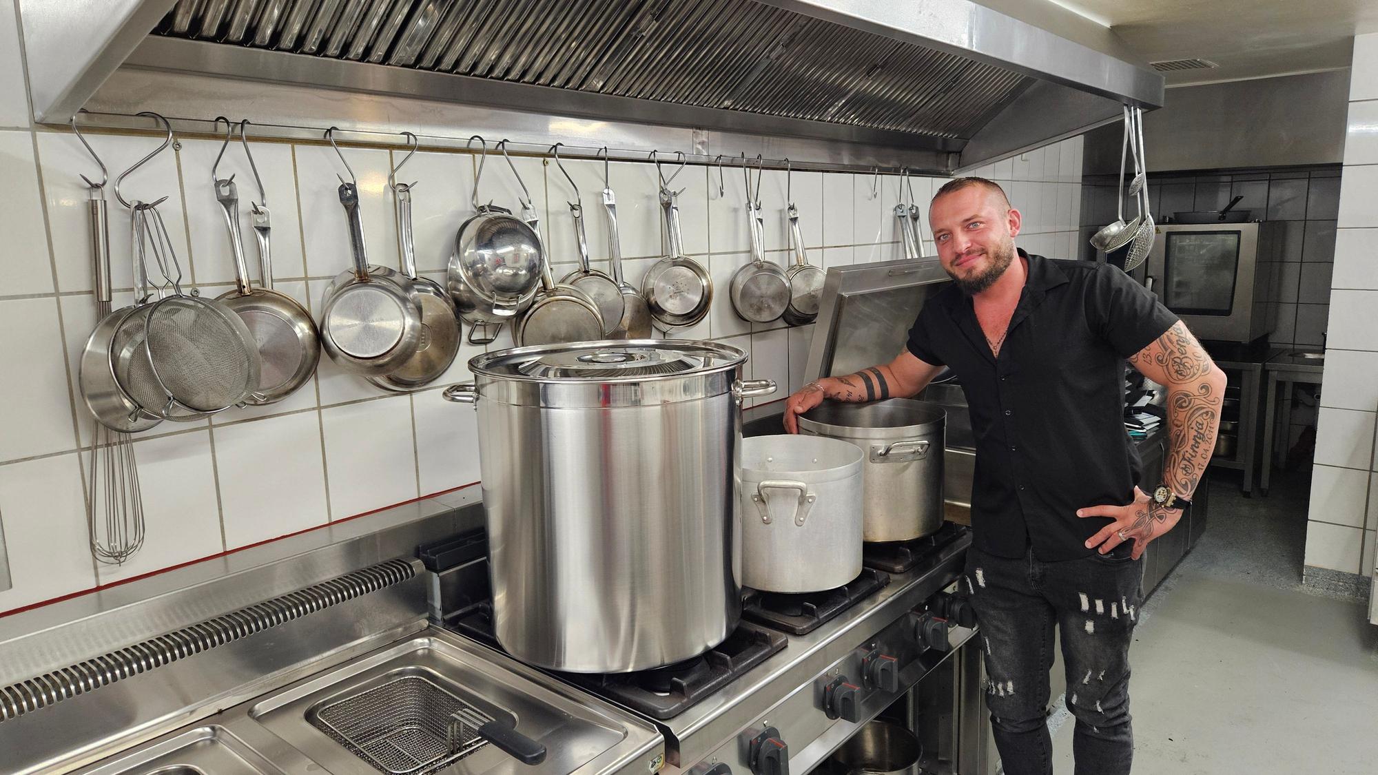 Maik Biedermann steht am Herd mit drei großen Kesseln.