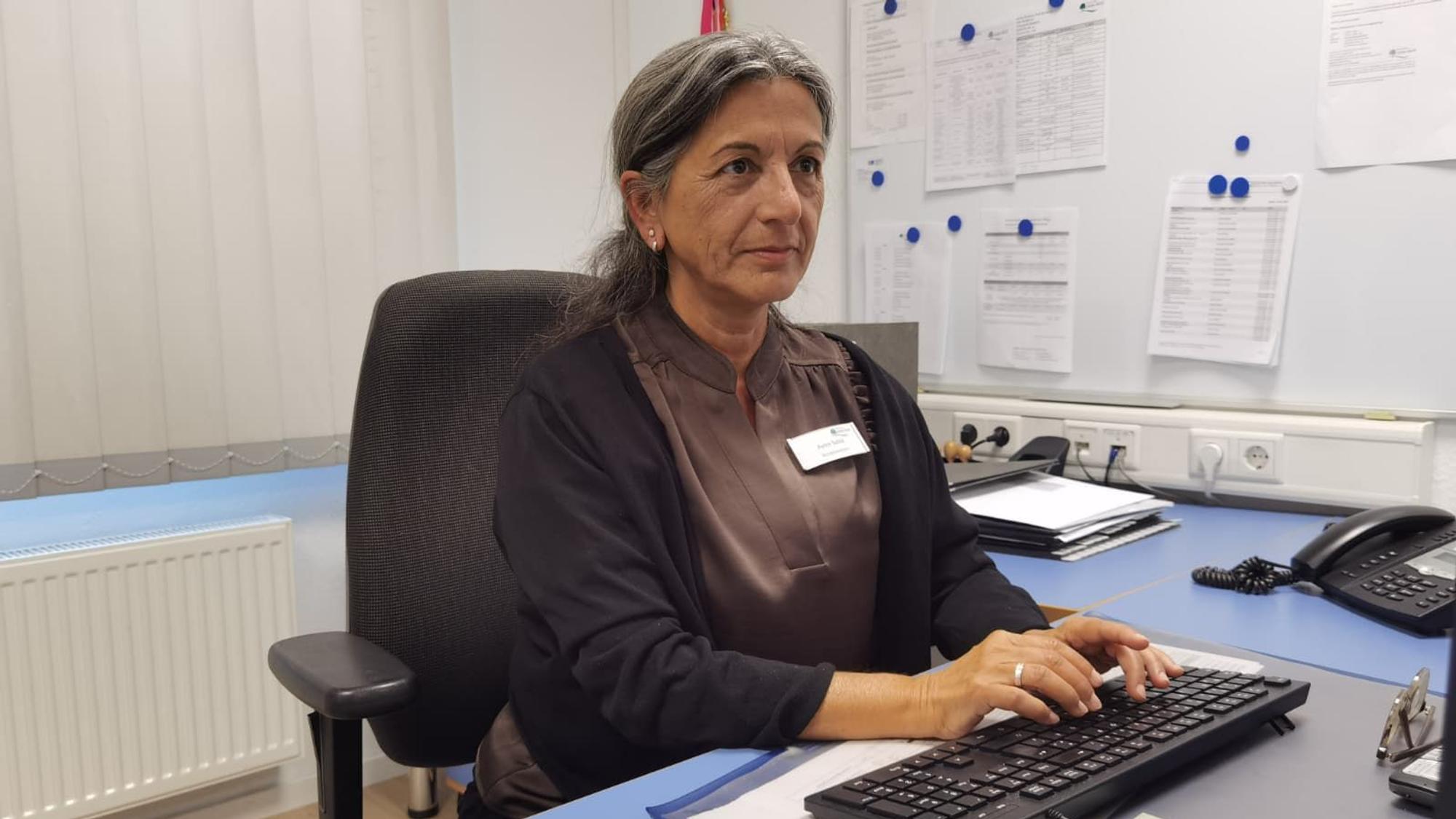 Eine Frau sitzt an einem Schreibtisch und tippt etwas in eine Tastatur.
